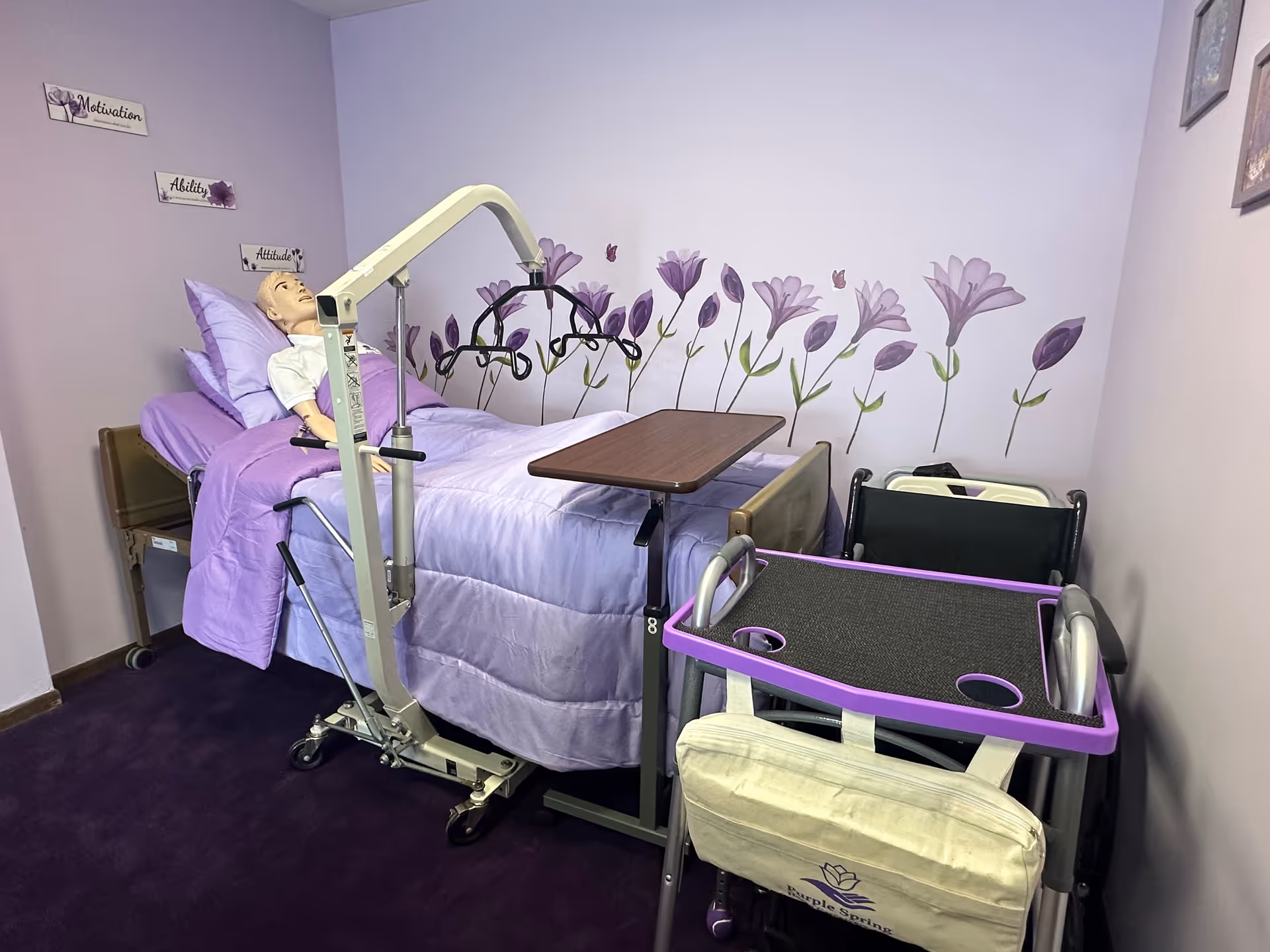 Purple-themed bedroom with adjustable hospital bed, patient lift, and wall mural.