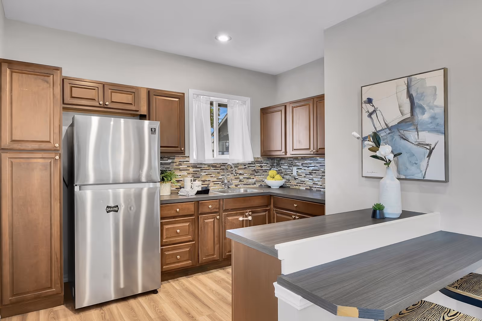 Modern kitchen in North Orchard Adult Family Home with wooden cabinets and stainless appliances.