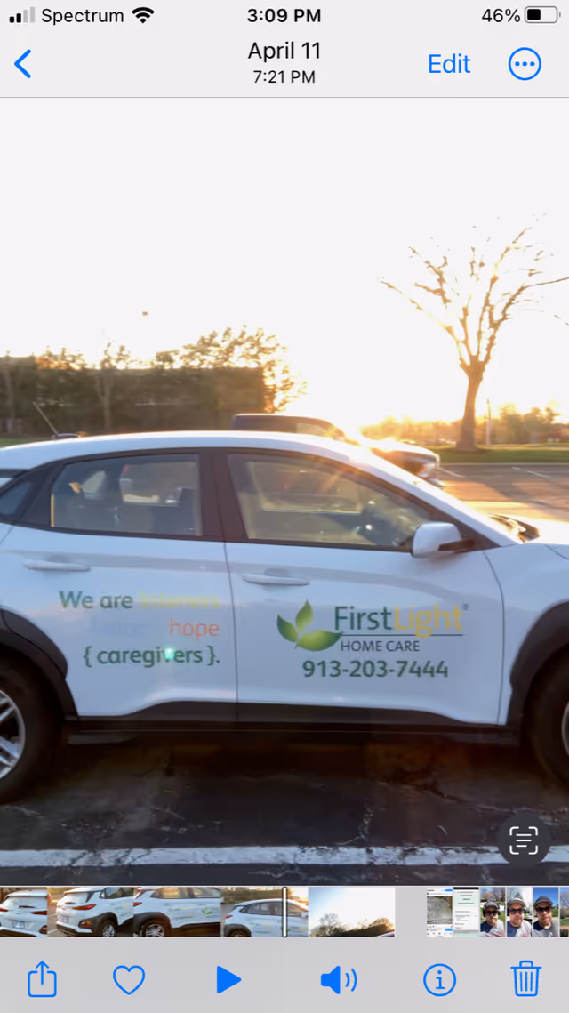 White FirstLight Home Care car with logo parked outdoors.