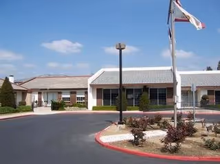 Exterior view of Inland Christian Home entrance with flags, driveway, and landscaped front.