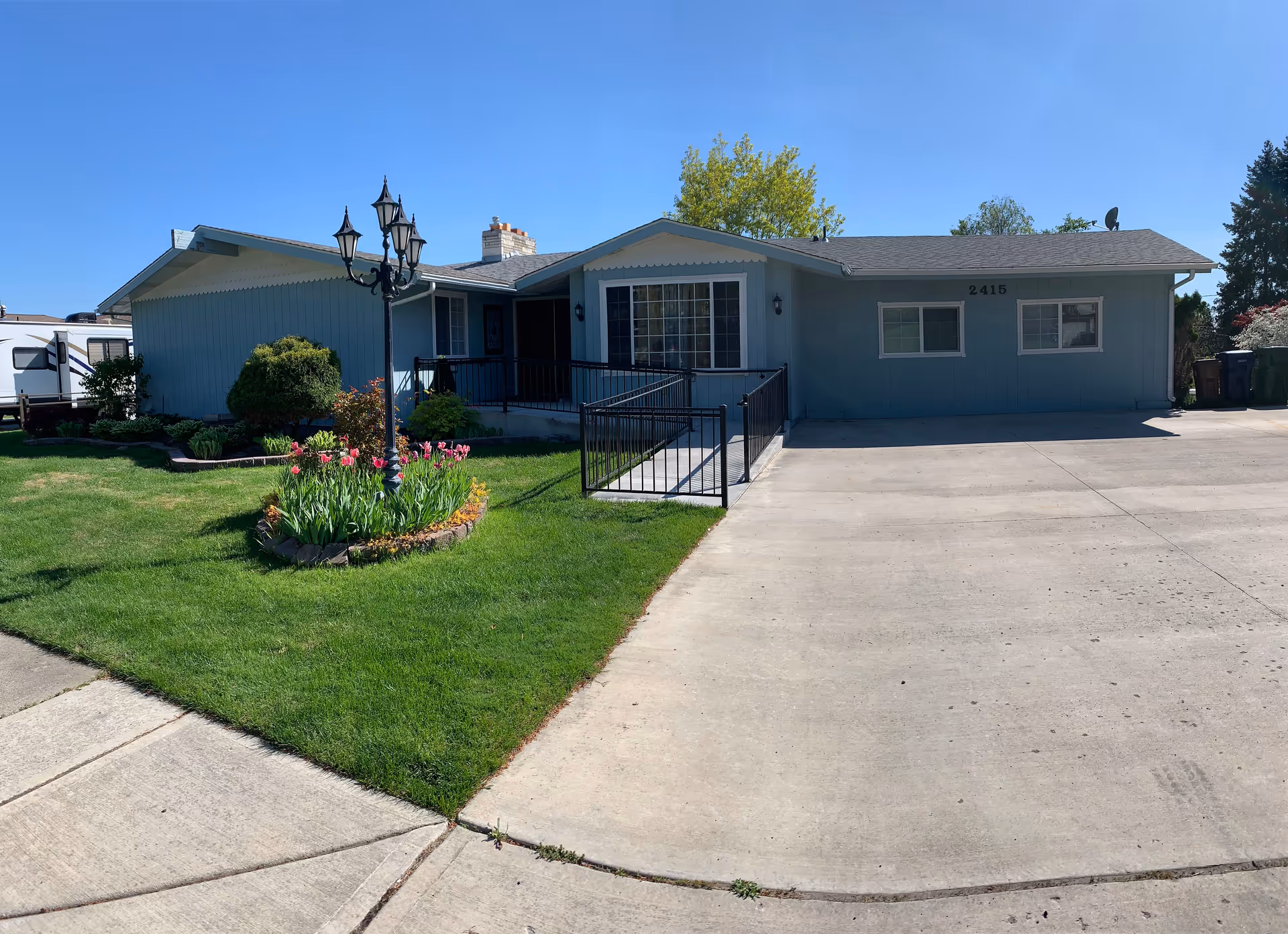 Front exterior view of Ark Home Care Adult Family Home with manicured lawn and driveway.