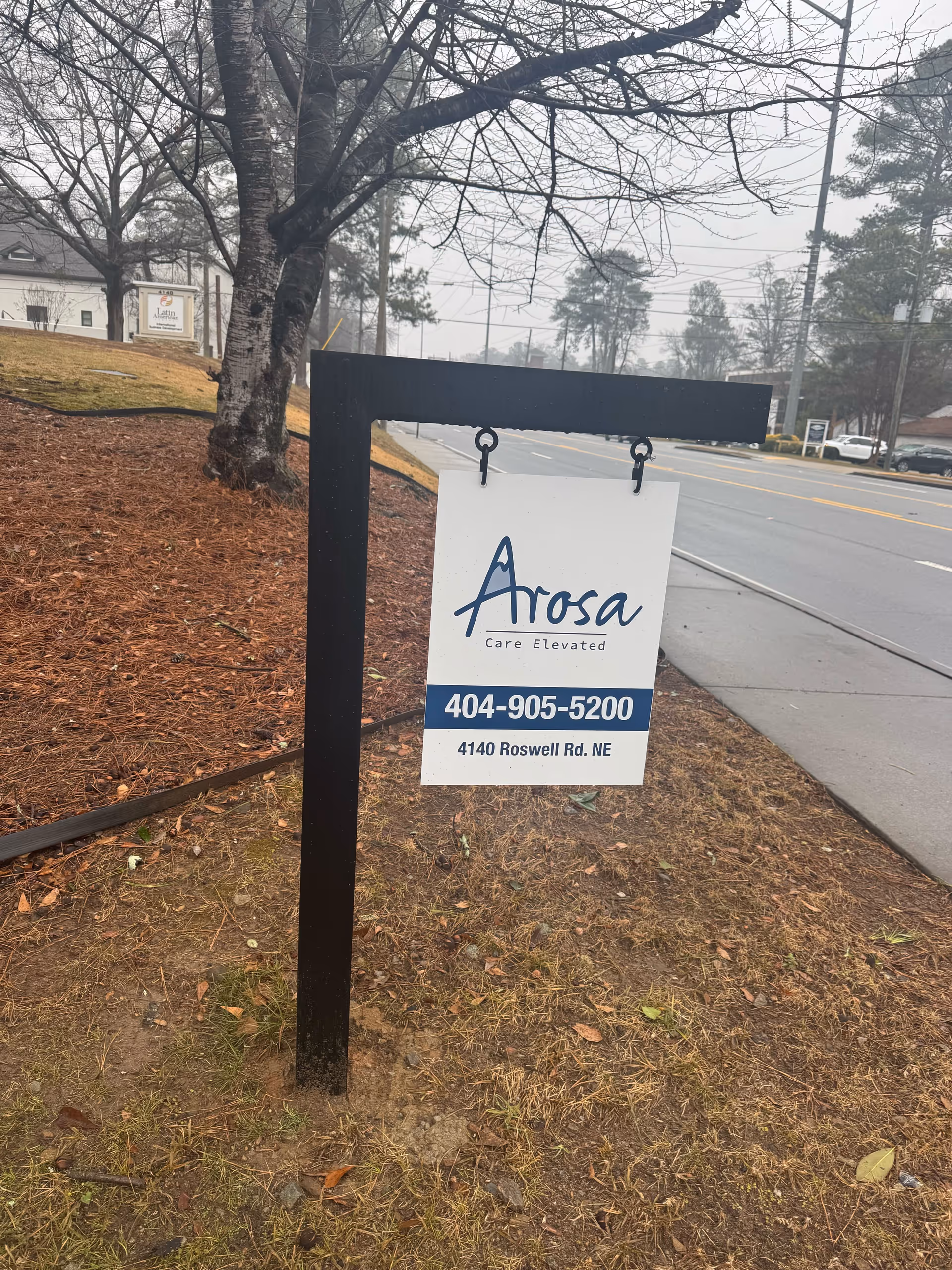 Outdoor sign for Arosa senior living along a street.