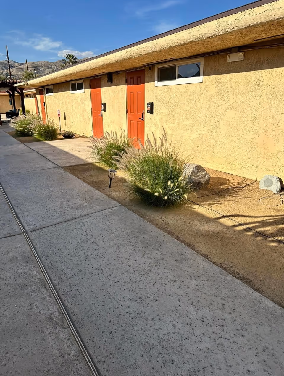 Exterior view of Desert Cove Assisted Living at Desert Hot Springs with orange doors.