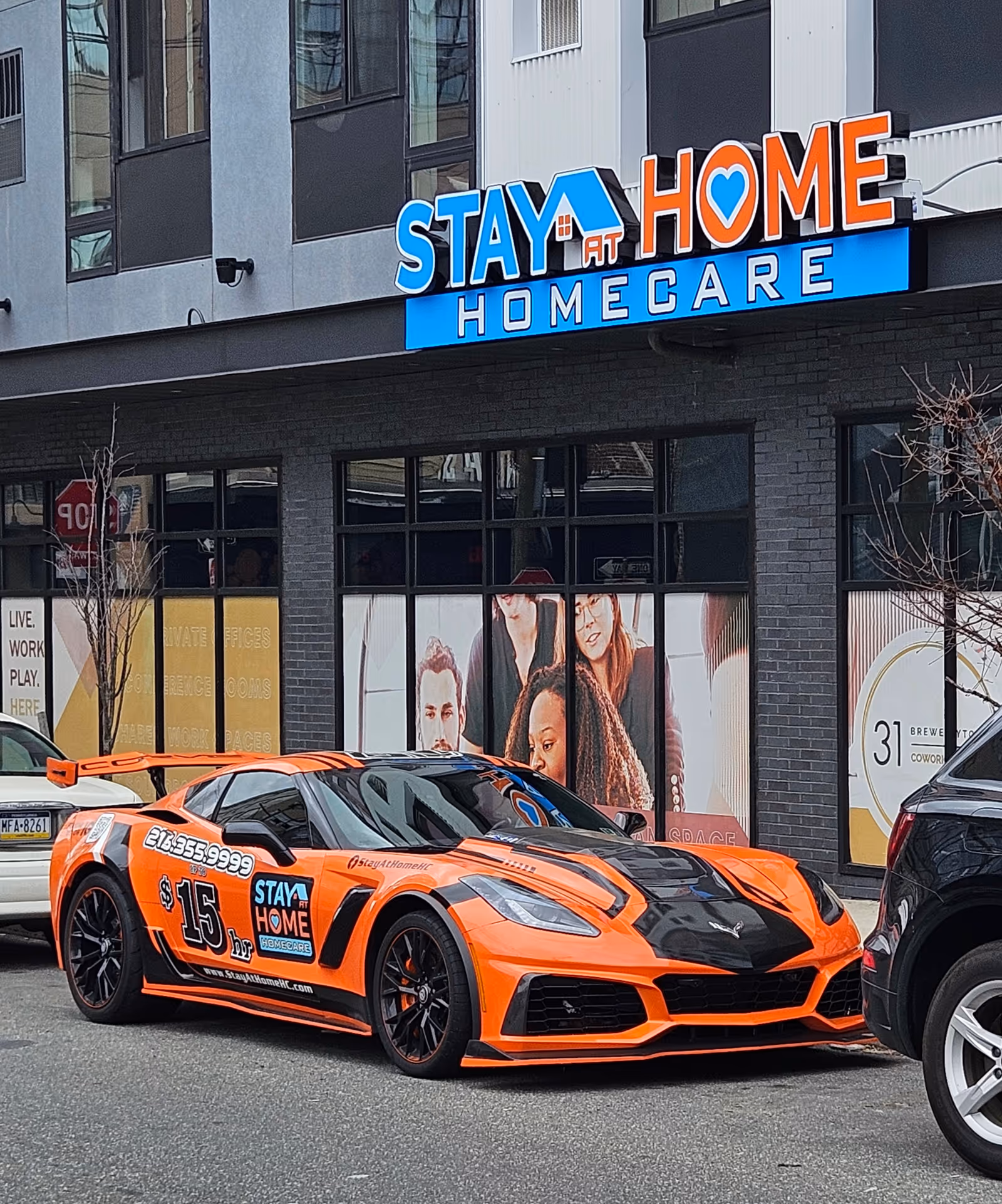 Orange sports car parked in front of Stay at Home Homecare storefront with large sign.