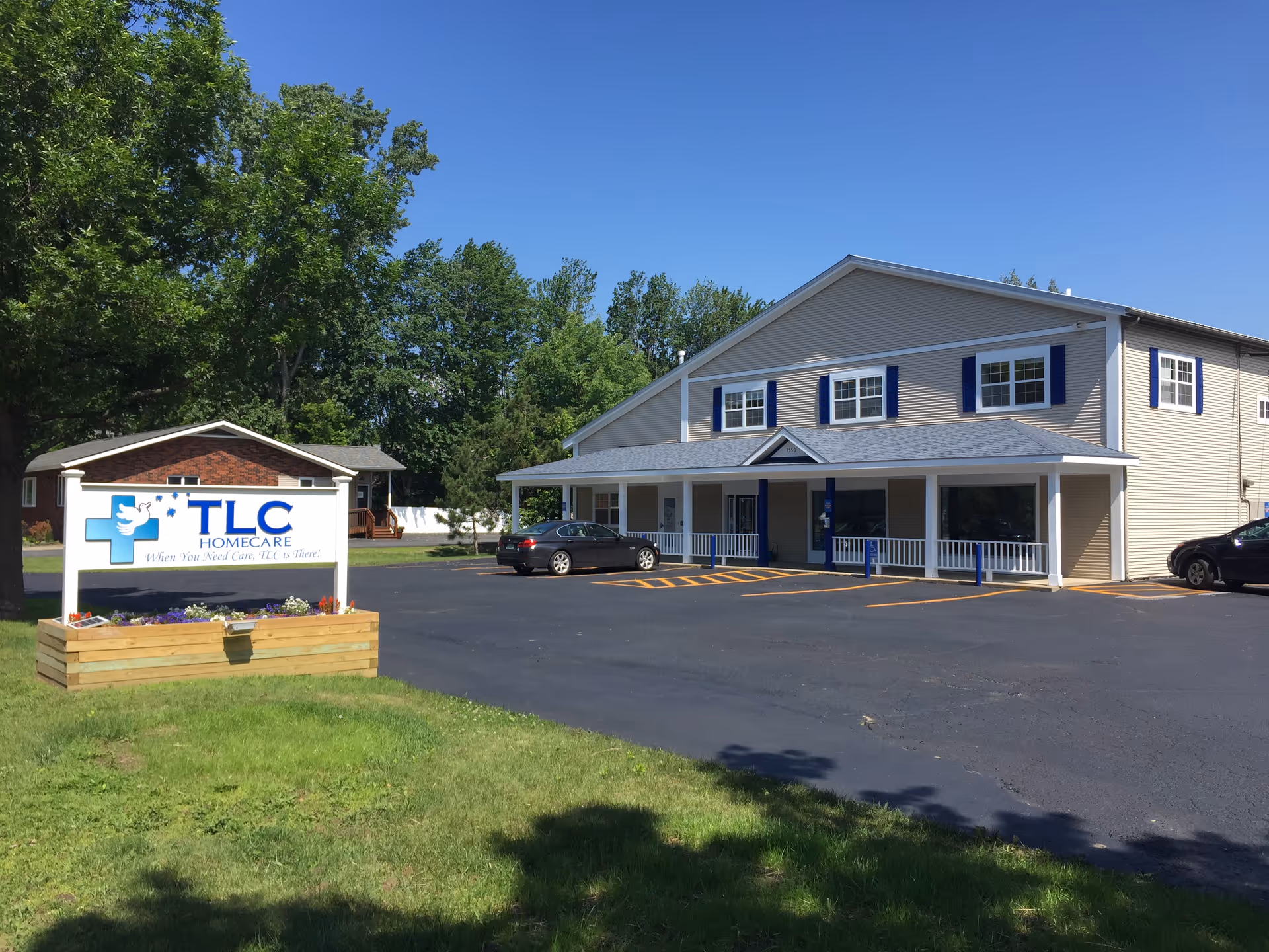 Exterior view of TLC HomeCare building with sign, parking lot, and entrance.