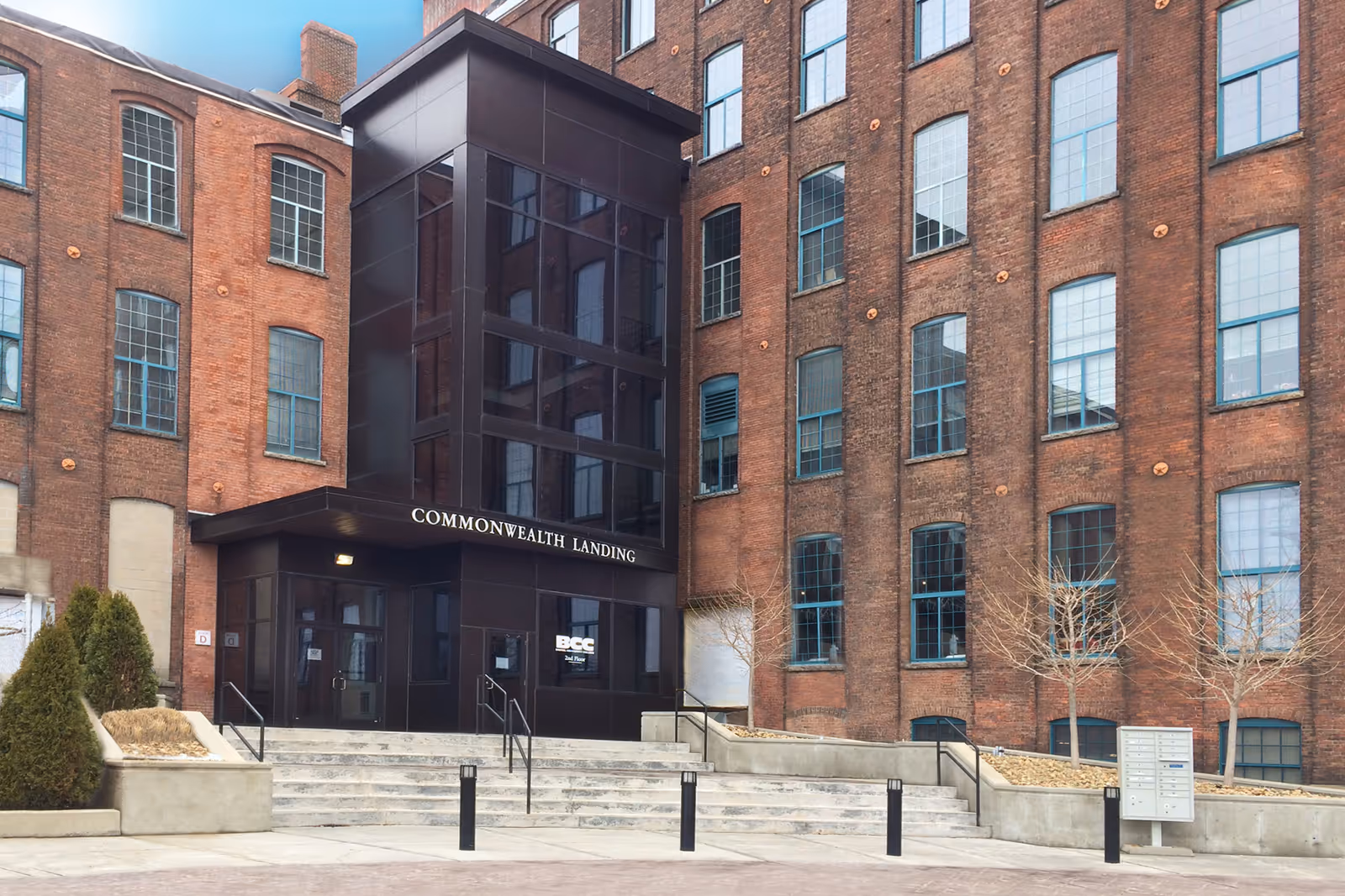 Brick building with a glass entrance labeled Commonwealth Landing and steps leading to the doorway.