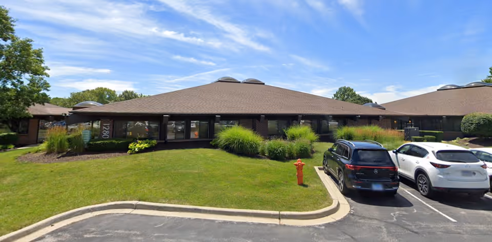 One-story senior living facility exterior with a parking lot and landscaped front yard.
