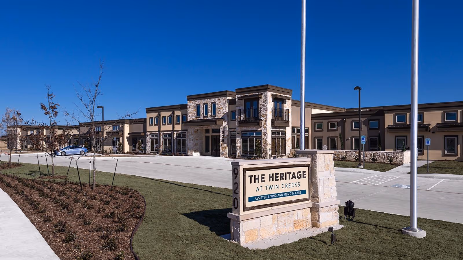 Exterior view of The Heritage at Twin Creeks senior living facility with sign.