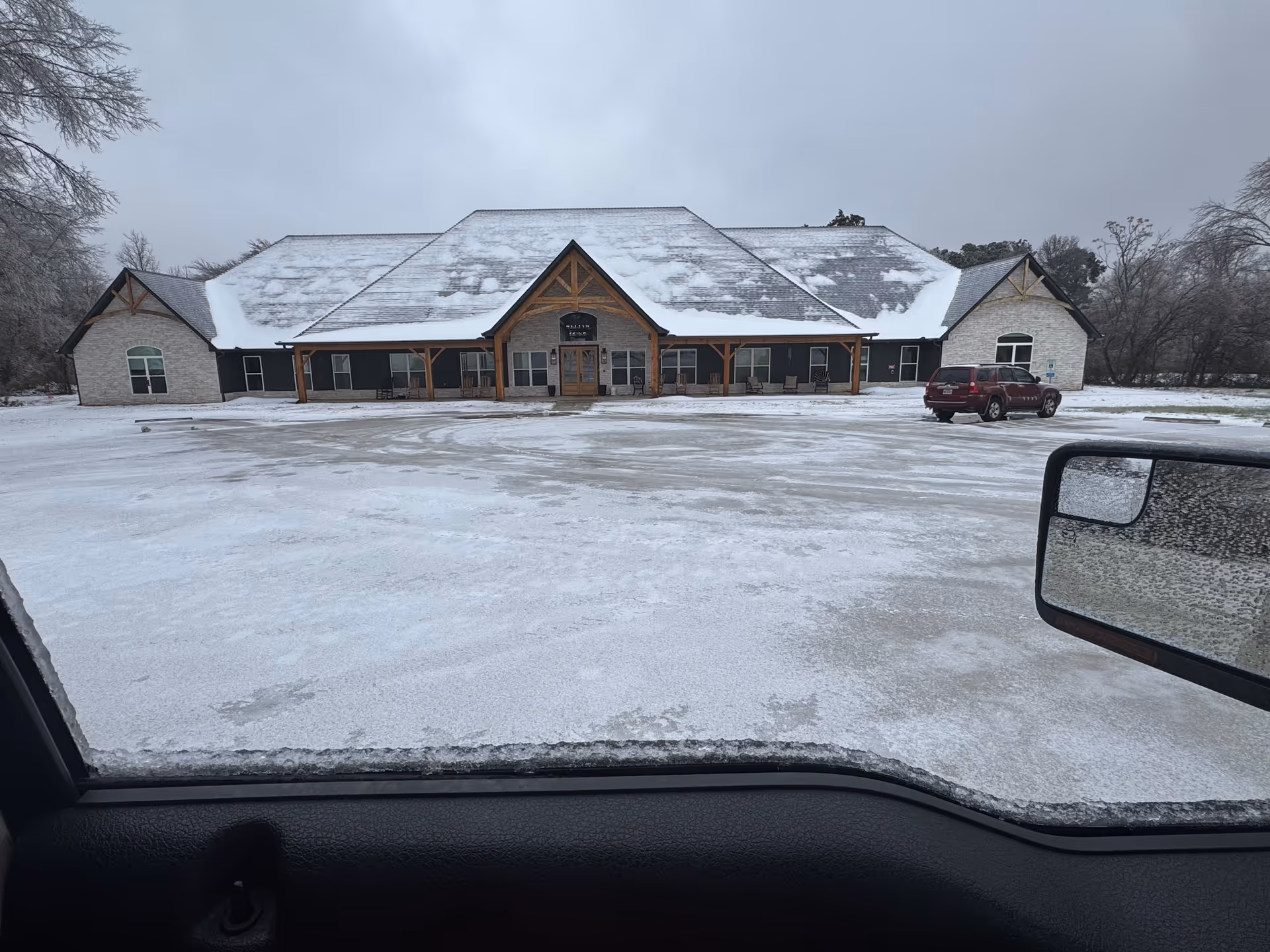 Snow-covered parking lot in front of McKee Assisted Living and Memory Care facility.