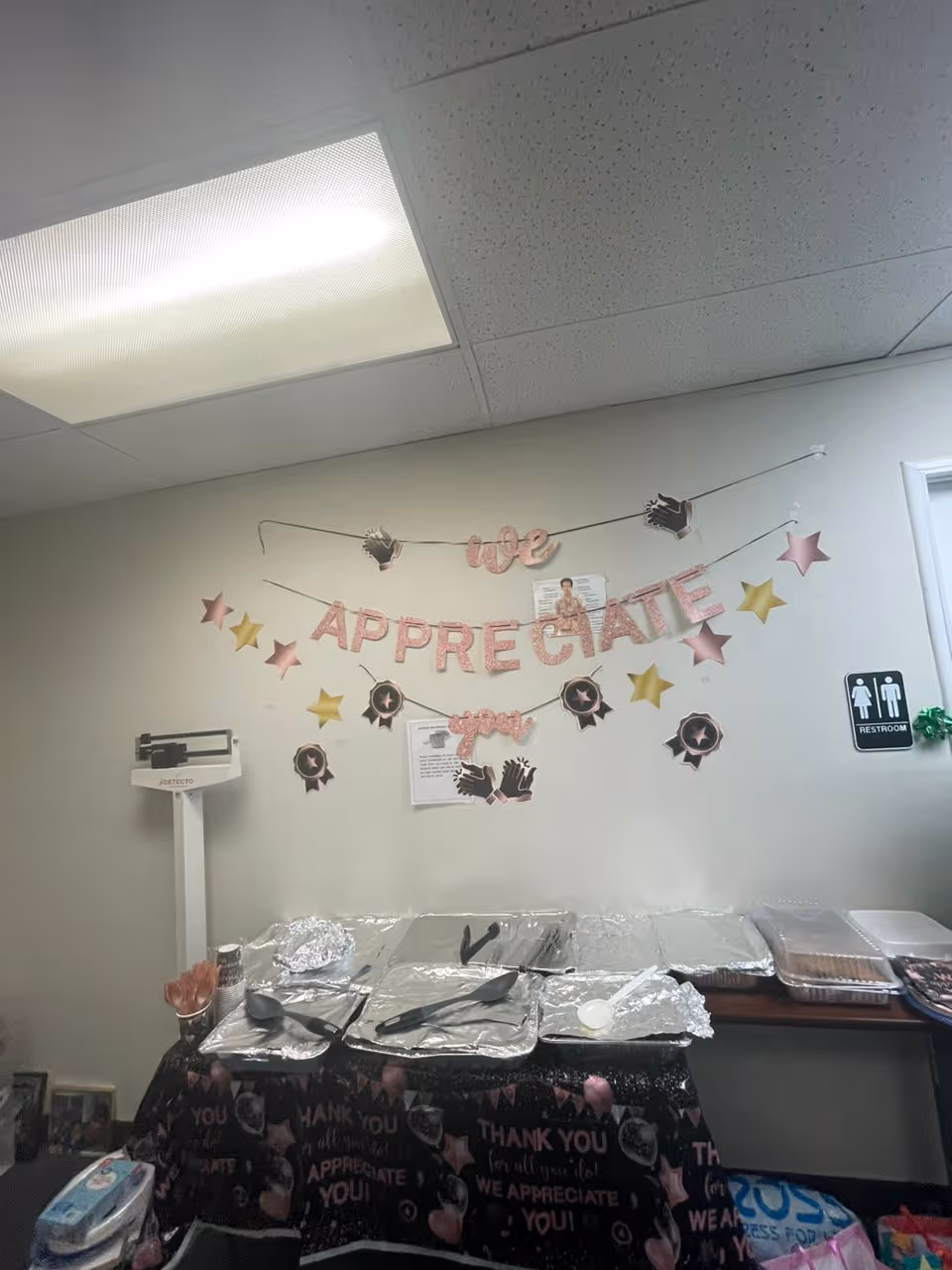 Dining area with foil trays and a wall banner reading 'We Appreciate You'.