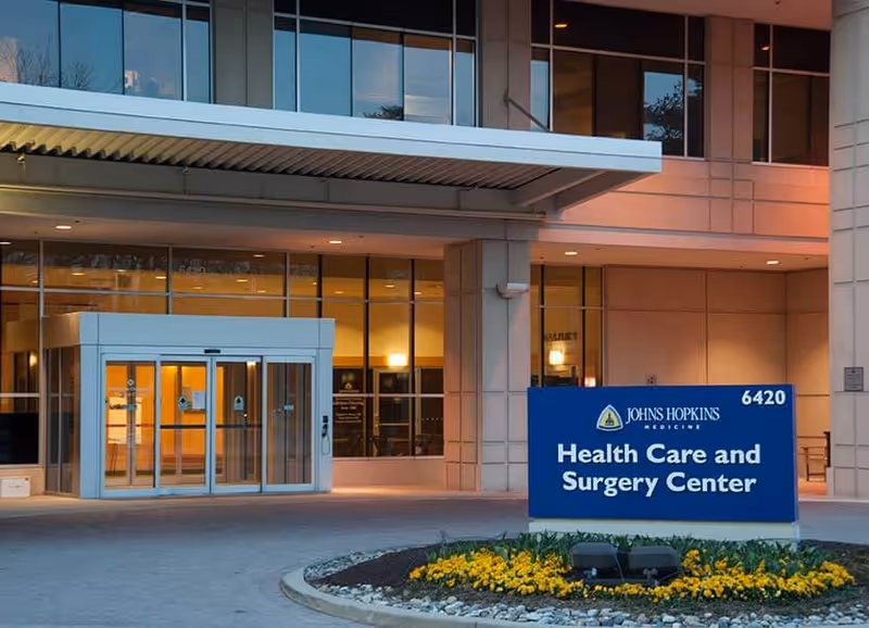 Exterior view of Johns Hopkins Health Care & Surgery Center entrance with a blue sign.