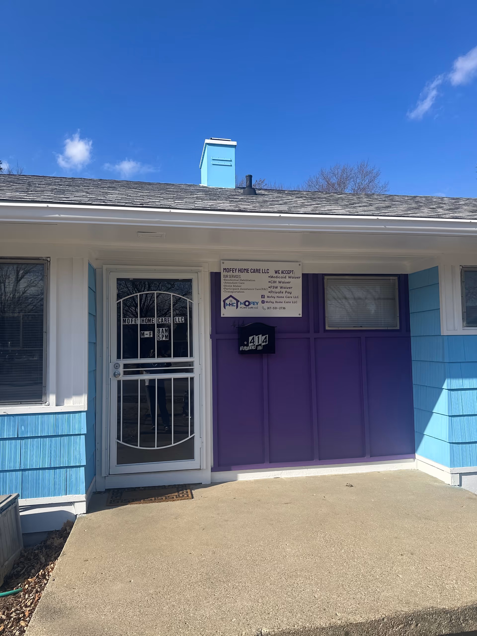 Front entrance of Mofey Home Care LLC with purple doors and blue siding.