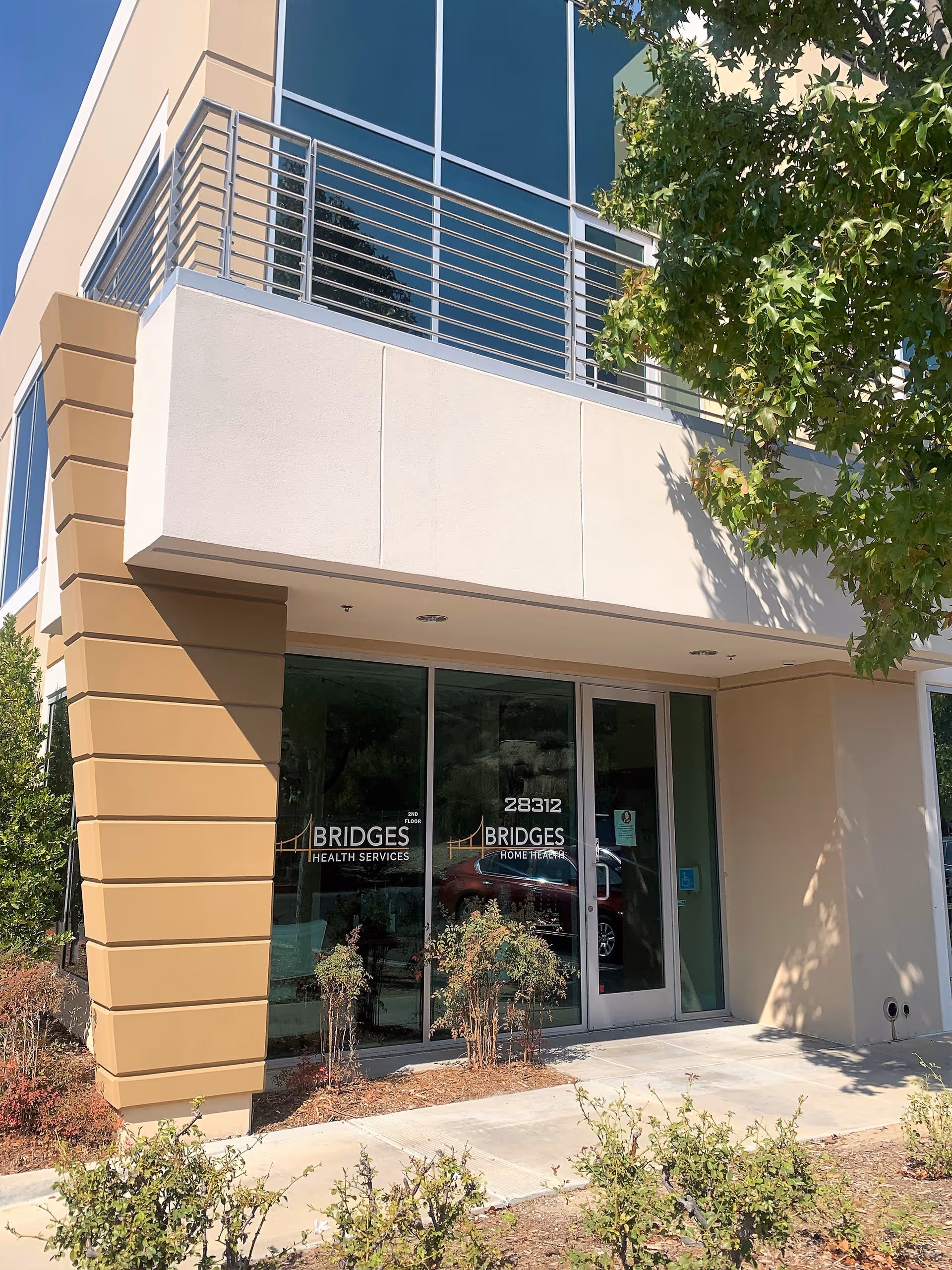 Modern building front with glass entrance doors and Bridges Health Services signage