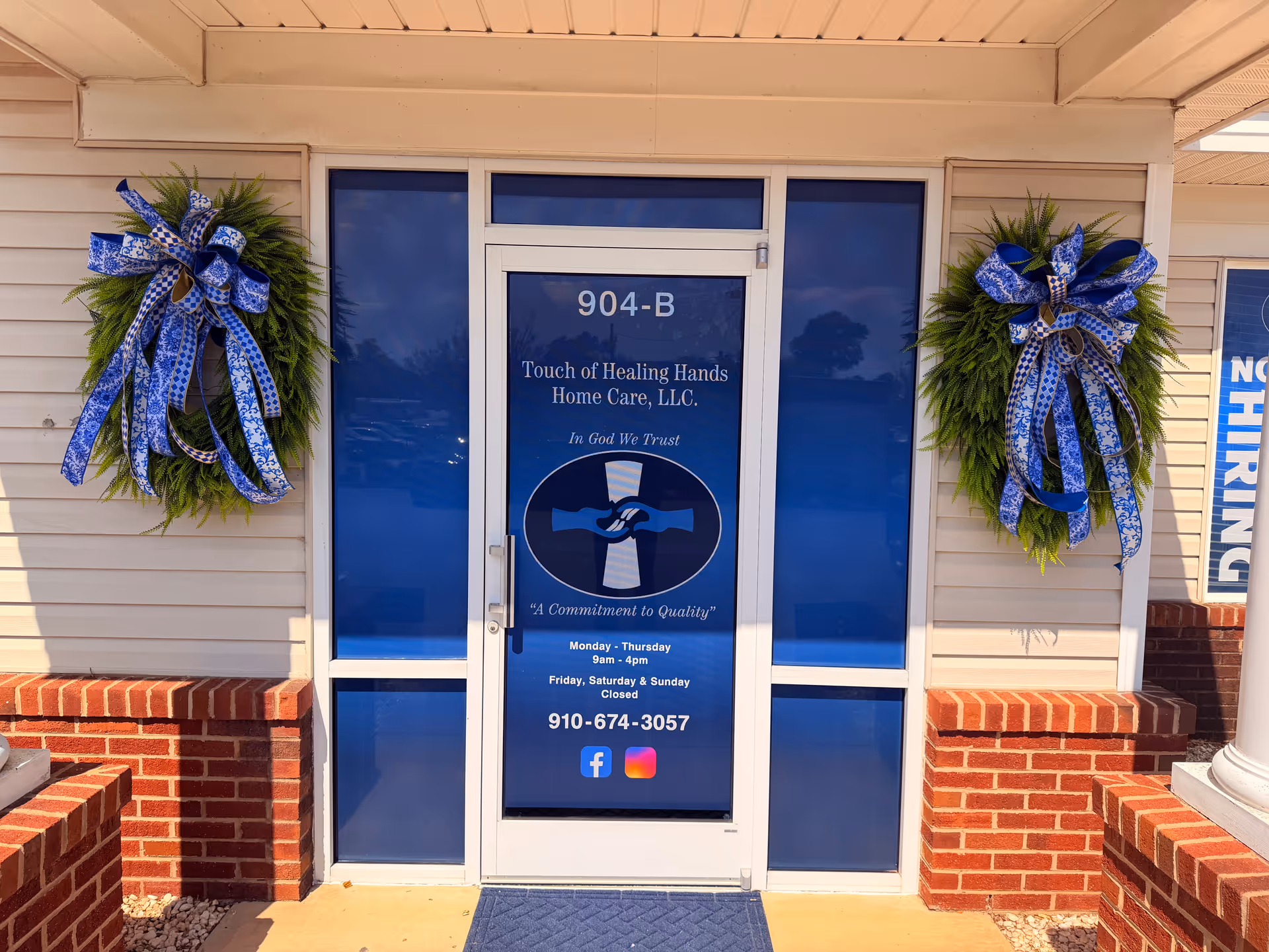Front entrance with blue doors and two large wreaths flanking the doorway.