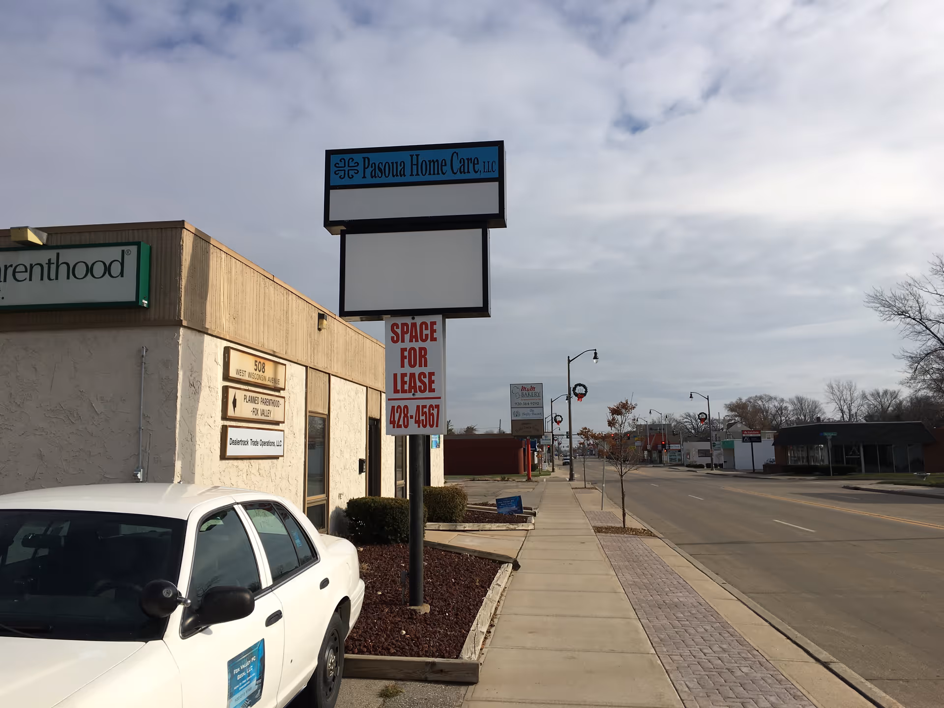 Exterior view of Pasoua Home Care LLC building with sign along a sidewalk
