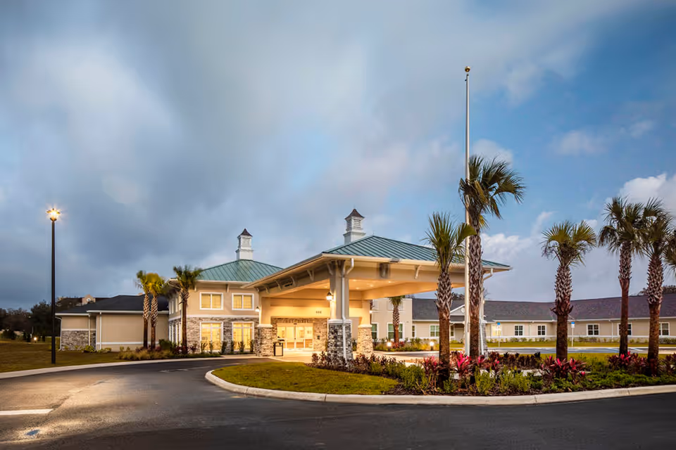 Front view of a health center entrance with porte-cochere and palm trees.