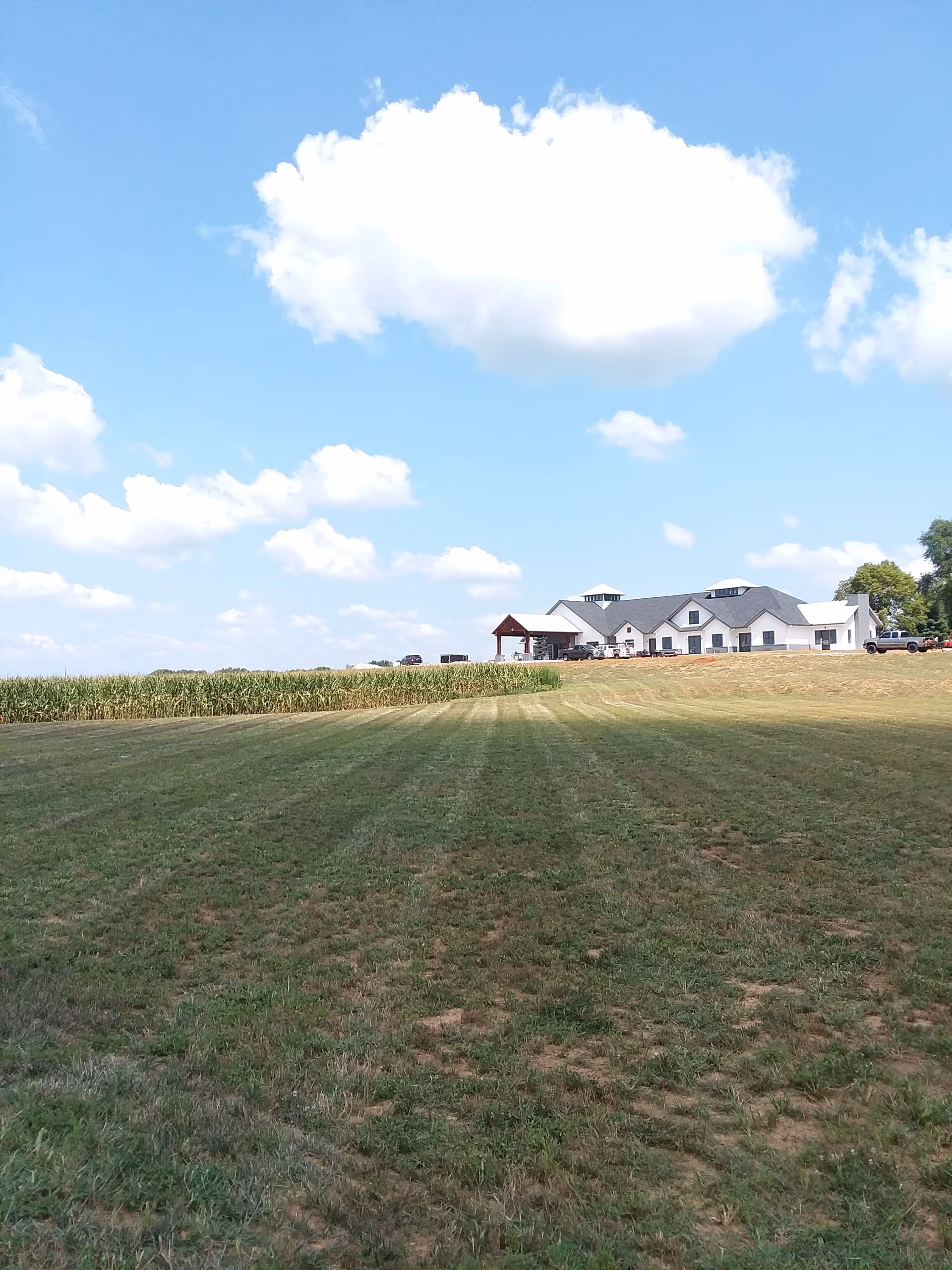 Wide view of Southern Kentucky Senior Living exterior with a grassy field and blue sky.