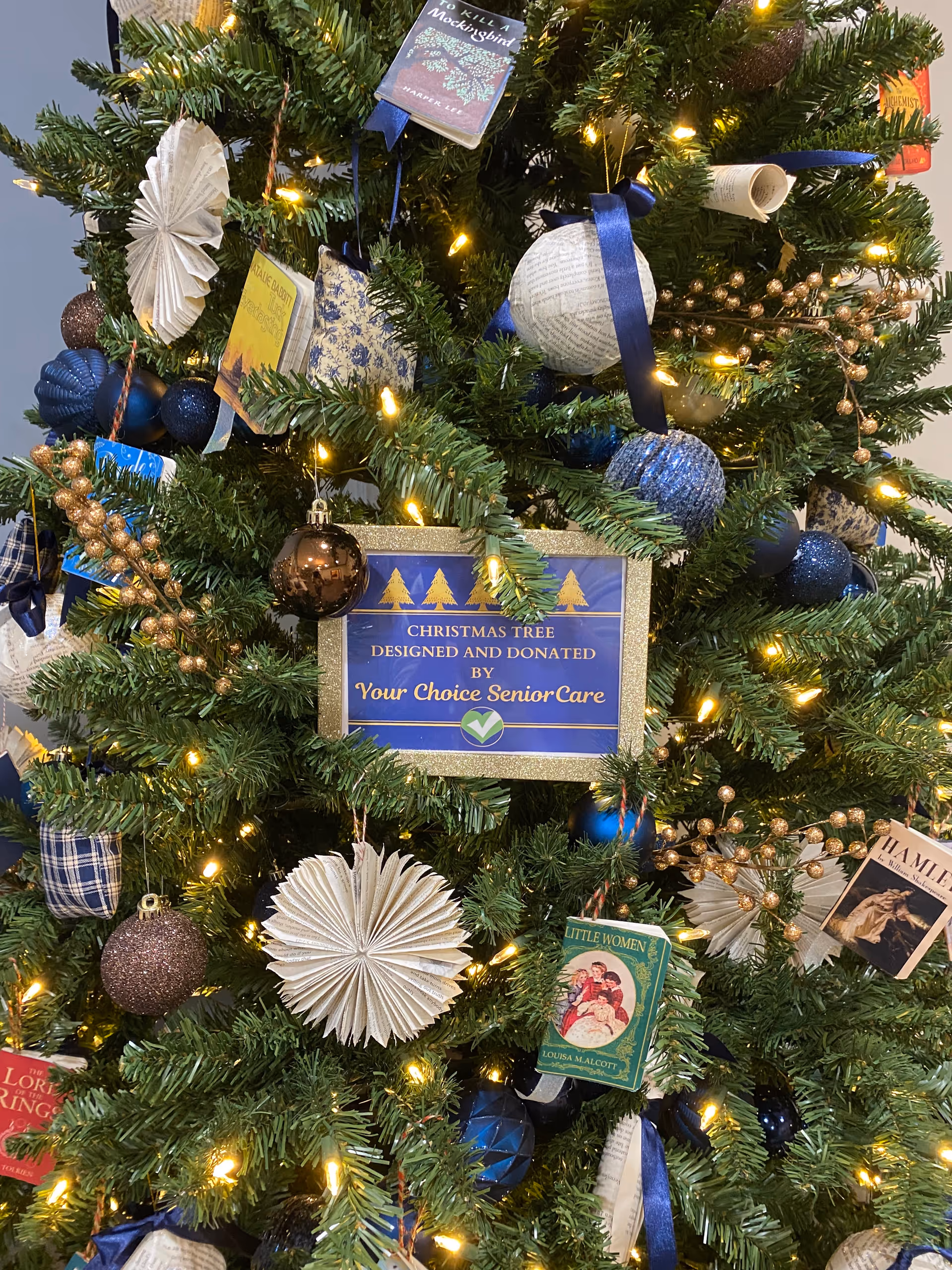 Close-up of decorated Christmas tree with a sign reading designed and donated by Your Choice SeniorCare.