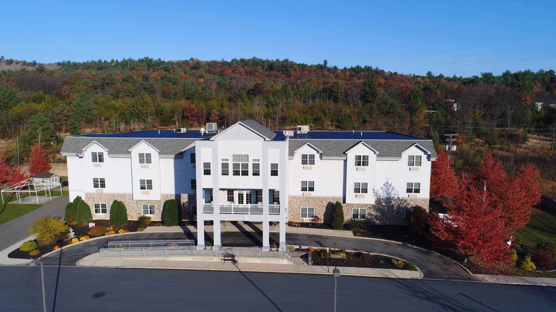 The Palmerton exterior: a white multi-story building with stone accents amid autumn trees.
