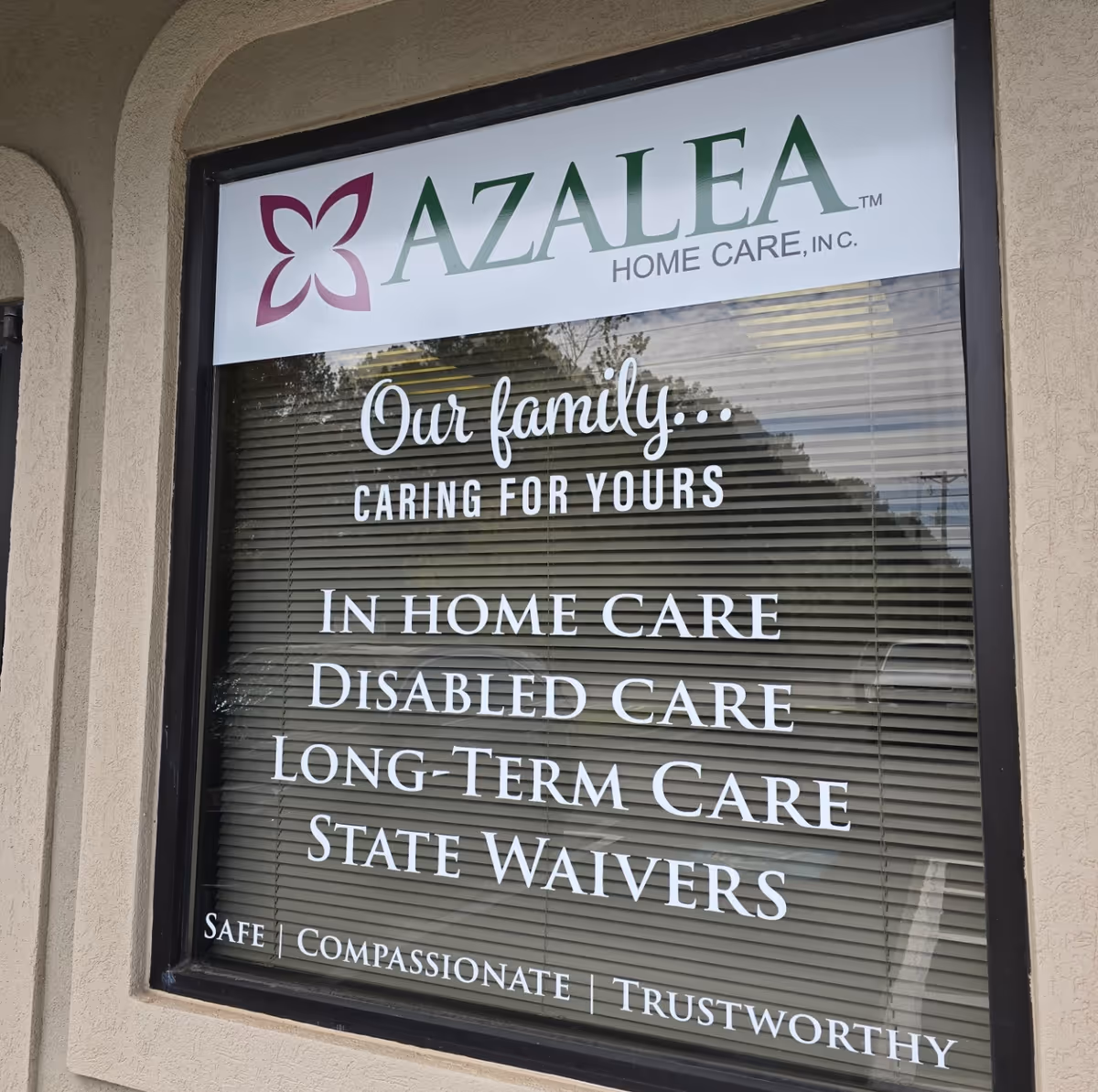Azalea Home Care storefront window sign displaying slogans about family care and services.