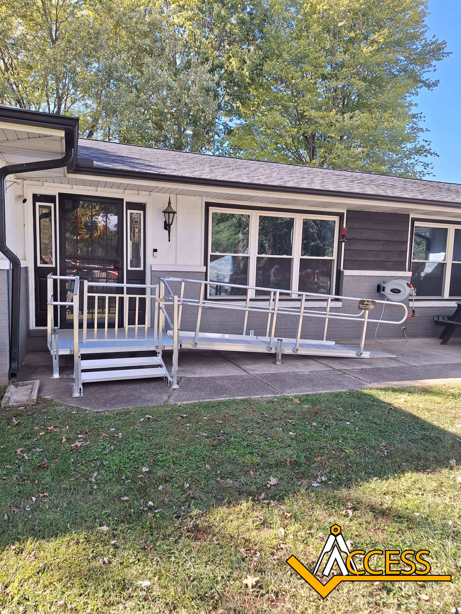 Exterior view of a senior living facility entrance with a metal wheelchair ramp.