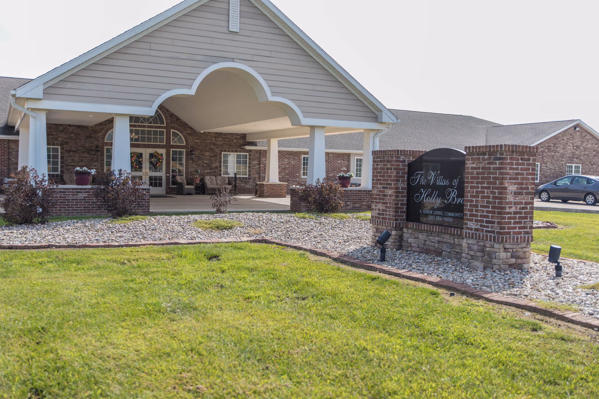 Front view of Villas of Holly Brook Marshall entrance with brick portico and sign.