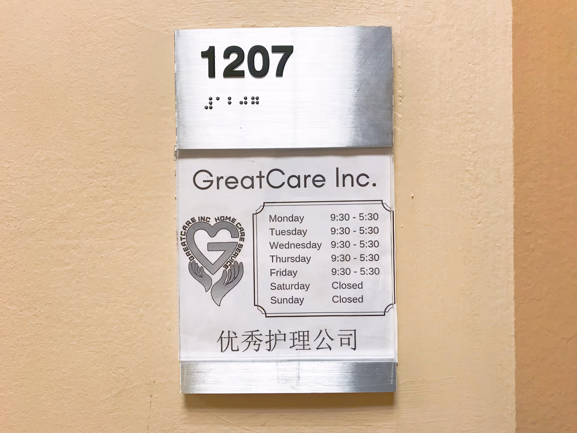 Exterior wall plaque showing 1207, GreatCare Inc. hours and logo.