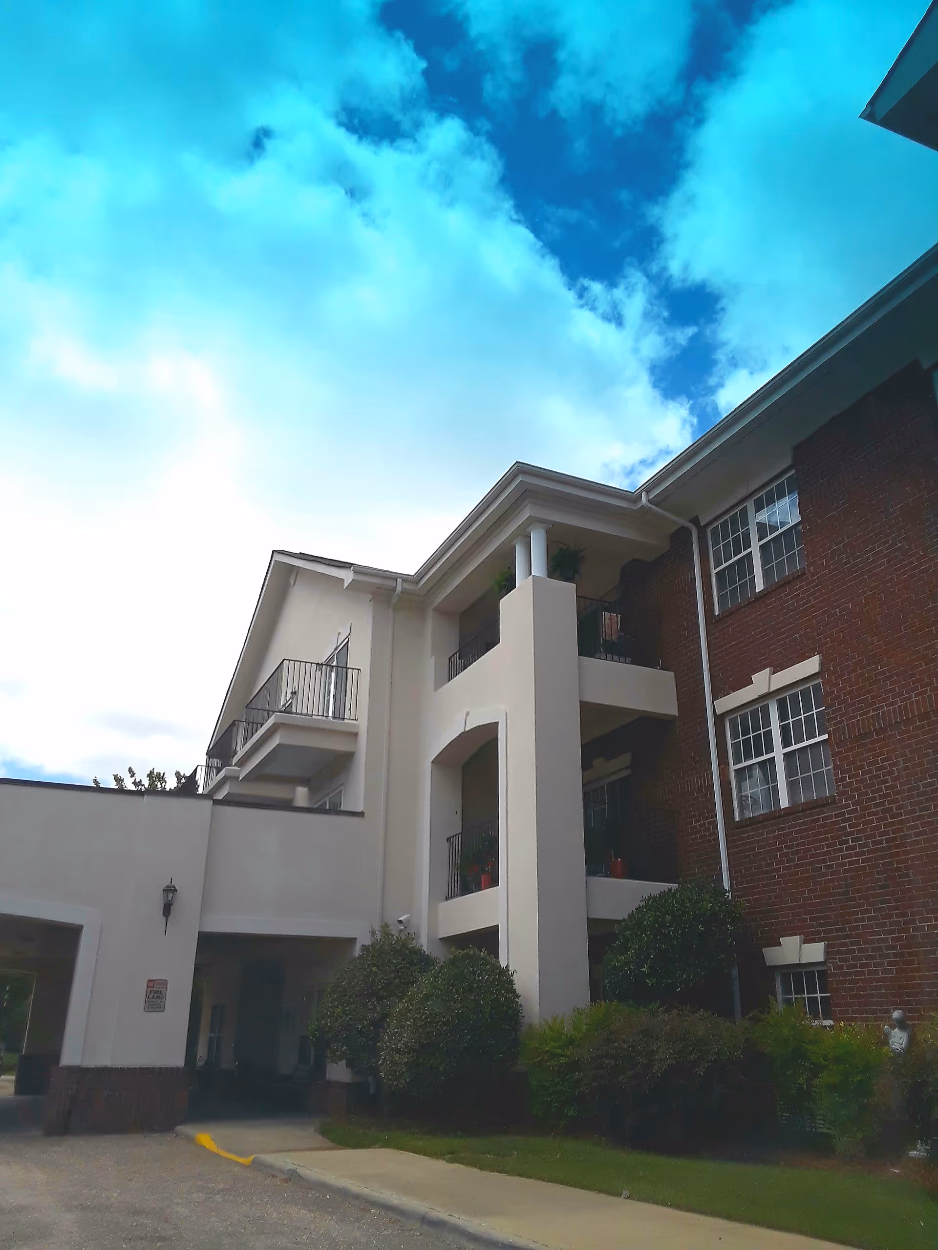 Exterior view of Windsor Point building with balconies under a blue sky.