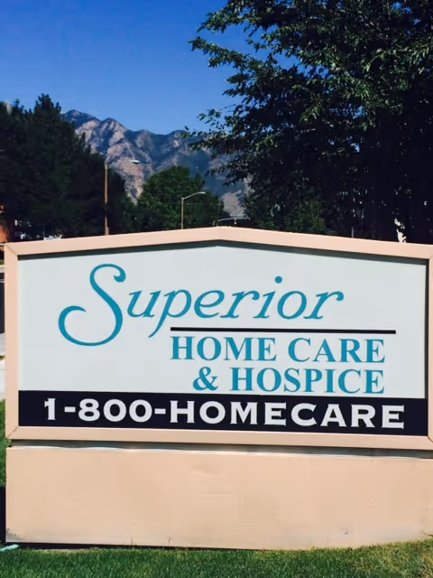 Outdoor sign for Superior Home Care and Hospice with mountains in background.