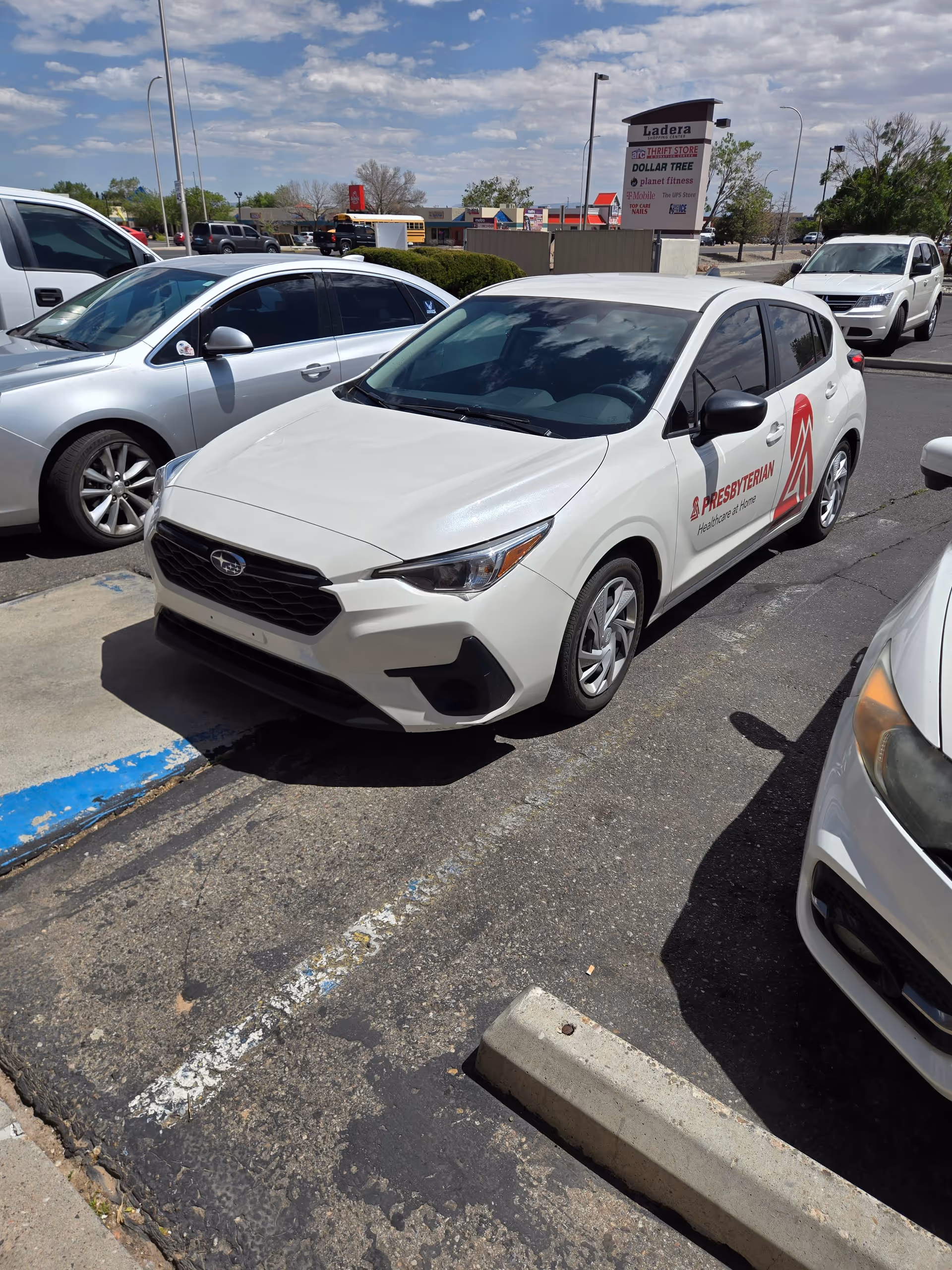 White Presbyterian Home Healthcare car parked in a busy outdoor lot with other vehicles.
