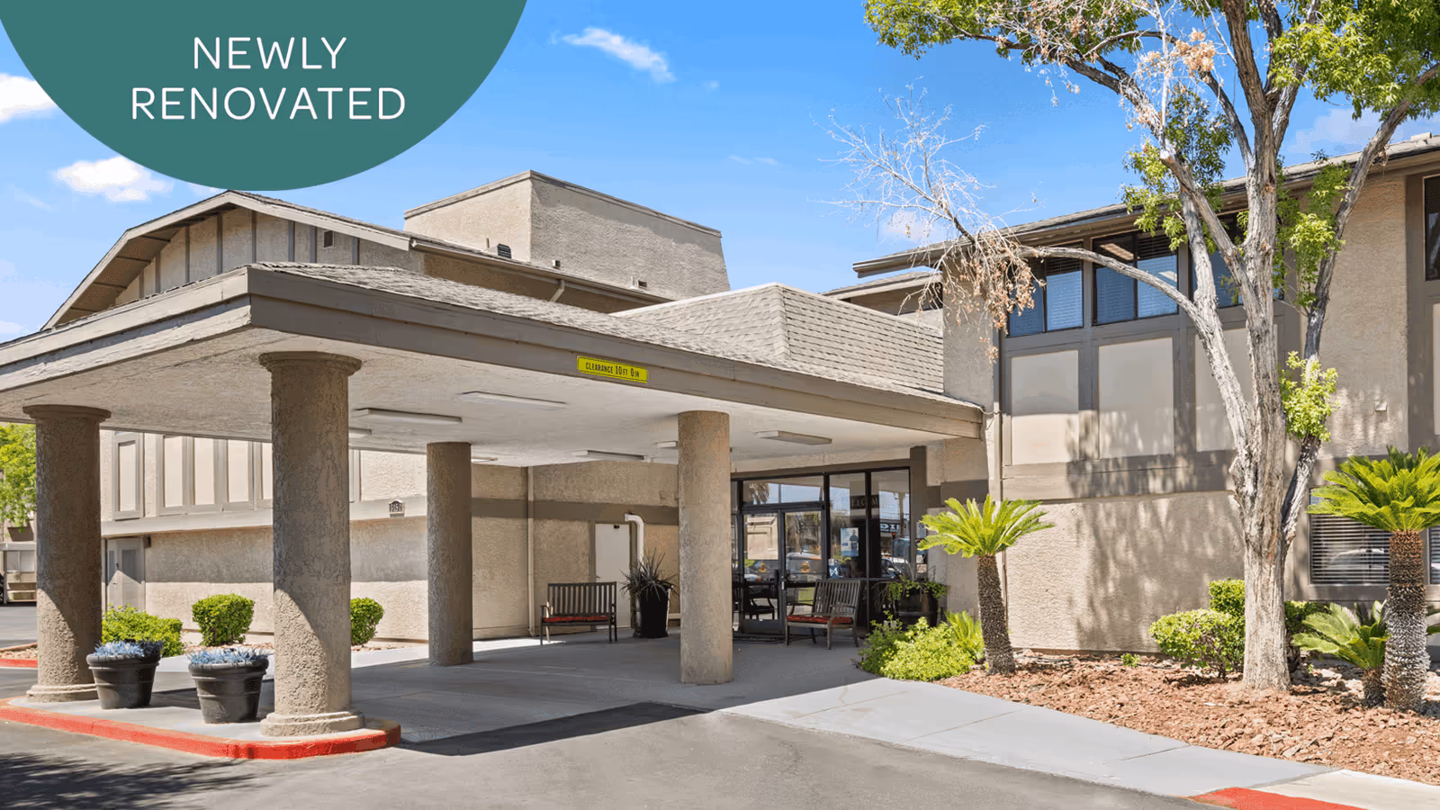 Exterior view of a senior living facility entrance with a covered drop-off.