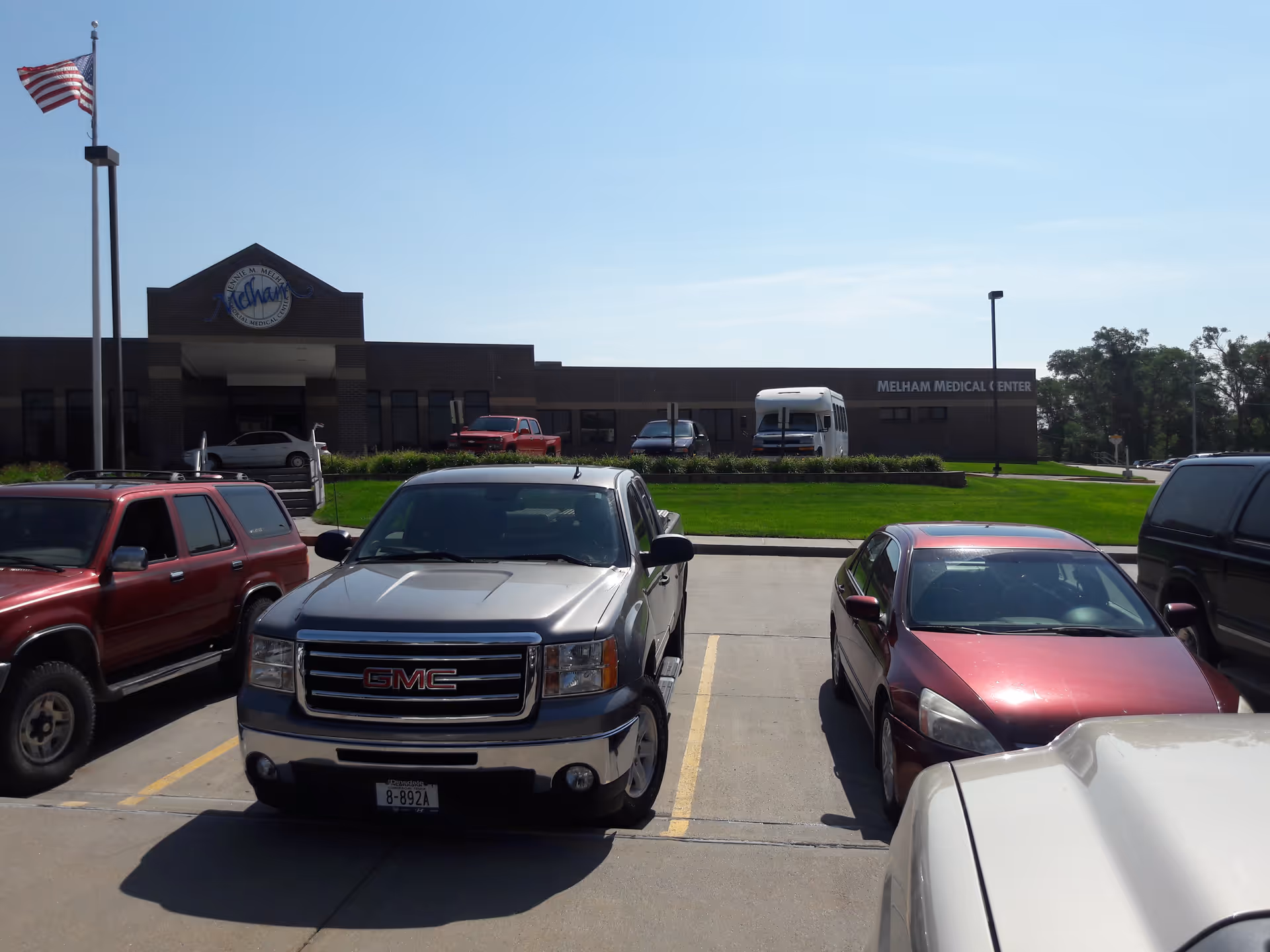 Parking lot foreground with GMC truck and medical center building in background