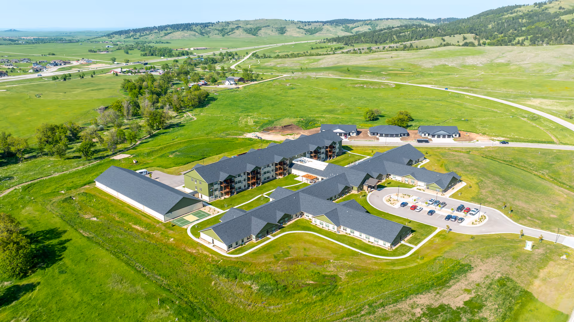 Aerial view of Peaceful Pines Senior Living campus with multiple buildings and parking