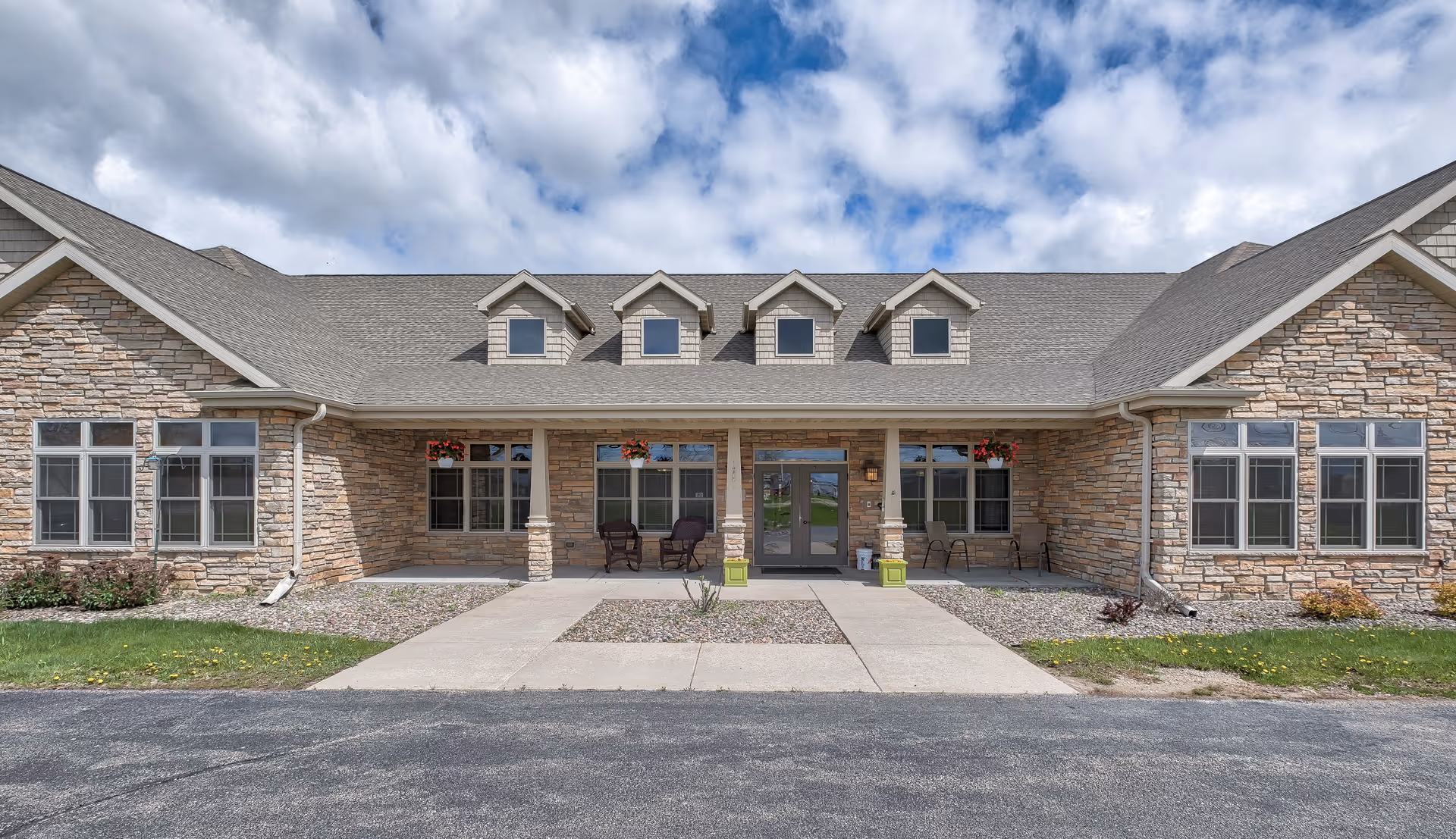 Front exterior of Landings of Kaukauna with stone facade and entrance pathway.