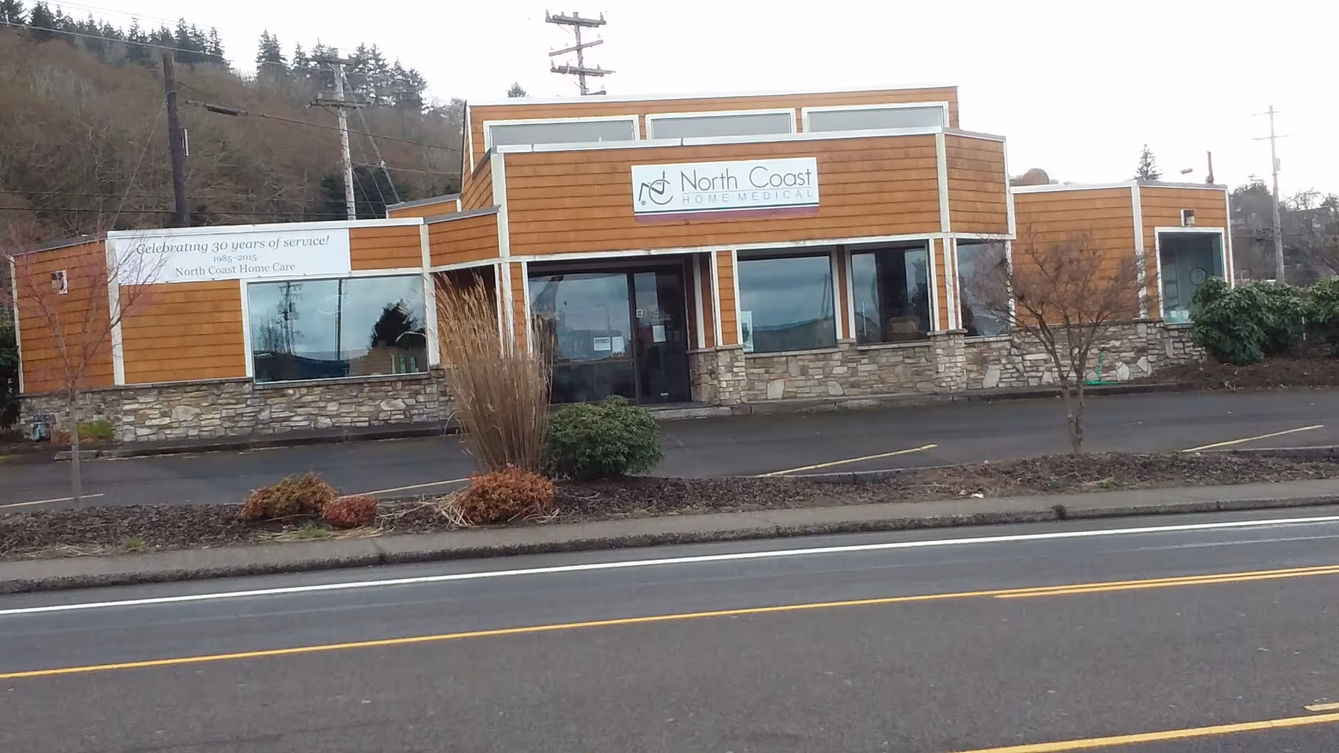 Exterior view of a modern facility with wood panels, stone base, and North Coast sign.
