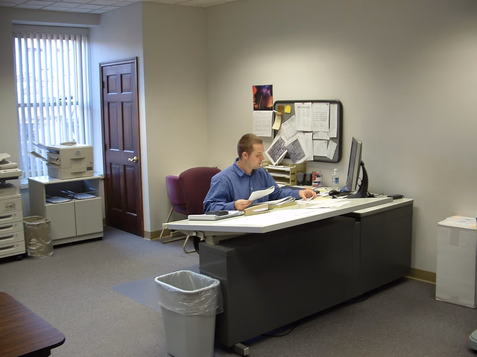 Office workspace inside Abundant Life Assisted Services with a man at a desk and papers.