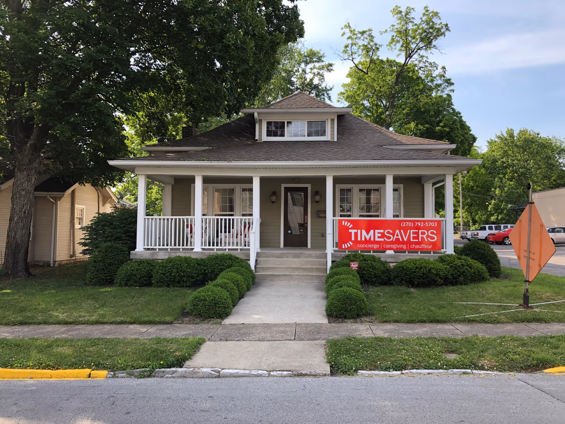 Front view of a residential-style building with a red Timesavers sign and manicured landscaping.