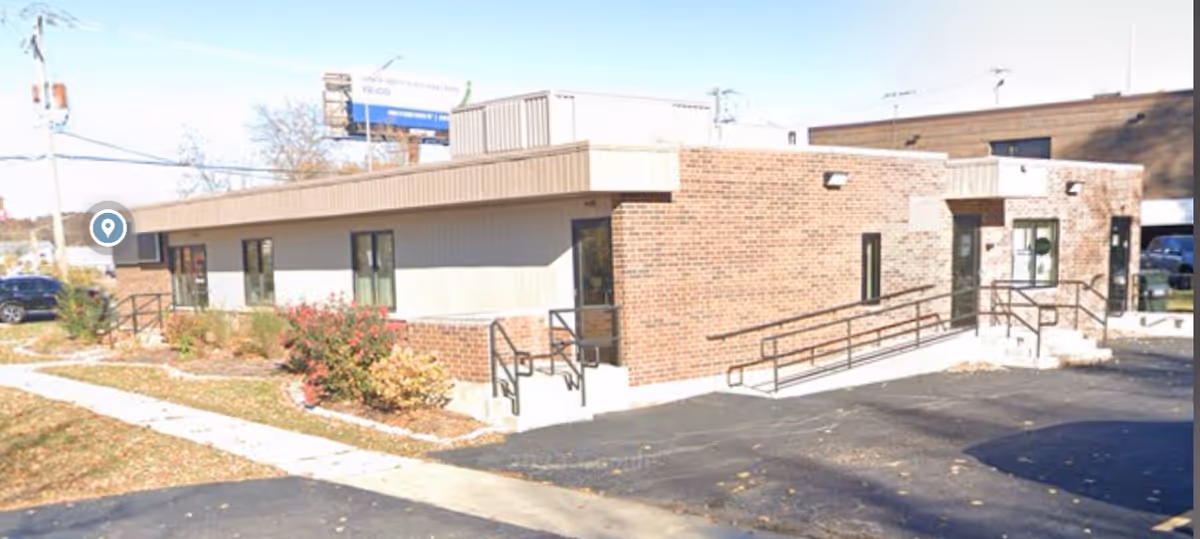 Exterior view of Medic Home Health Care building with brick facade, ramps, and parking.