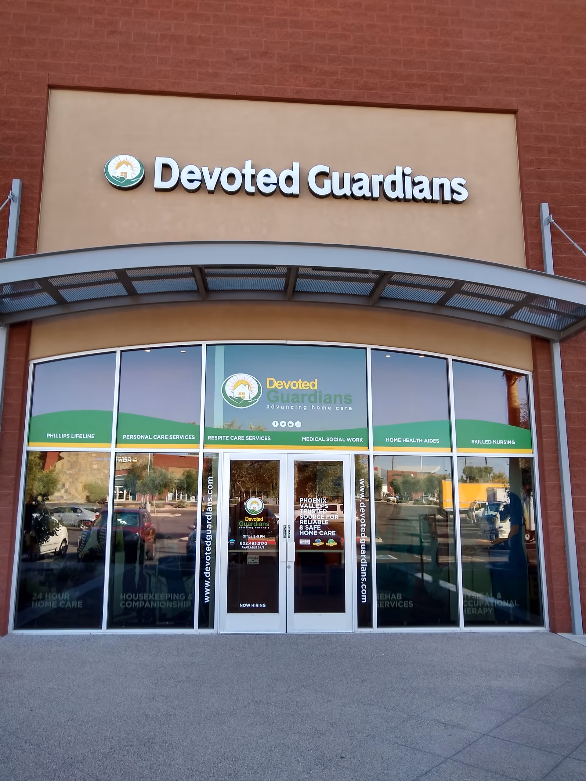 Front view of Devoted Guardians Home Care facility with glass doors and sign.