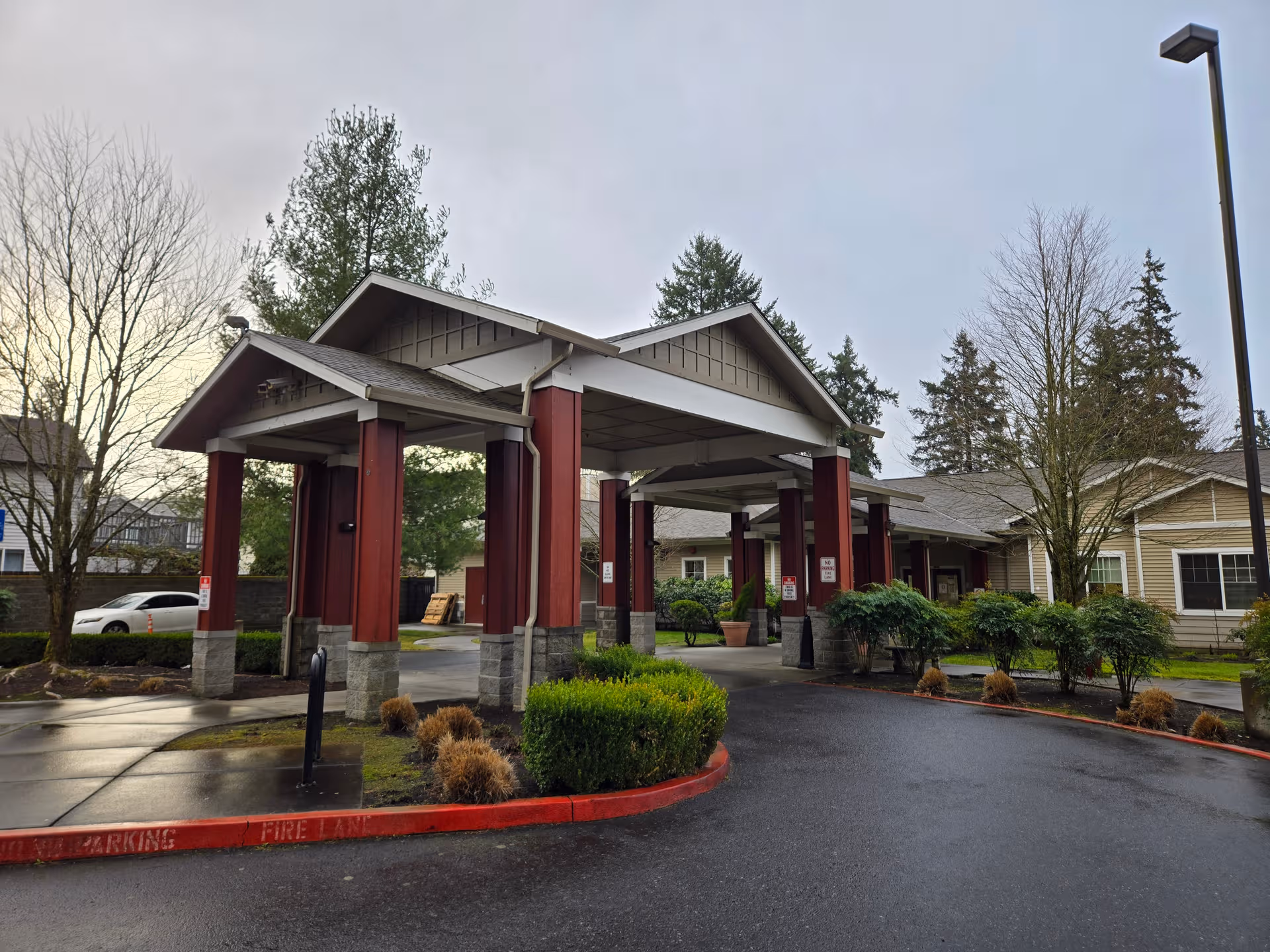 Exterior view of Avalon Care Center Portland with a covered entrance and red columns.