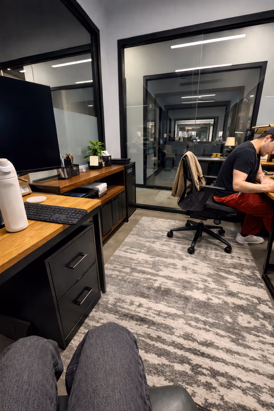 Office workspace inside a senior facility, with desk, computer, and a man seated at a workstation.