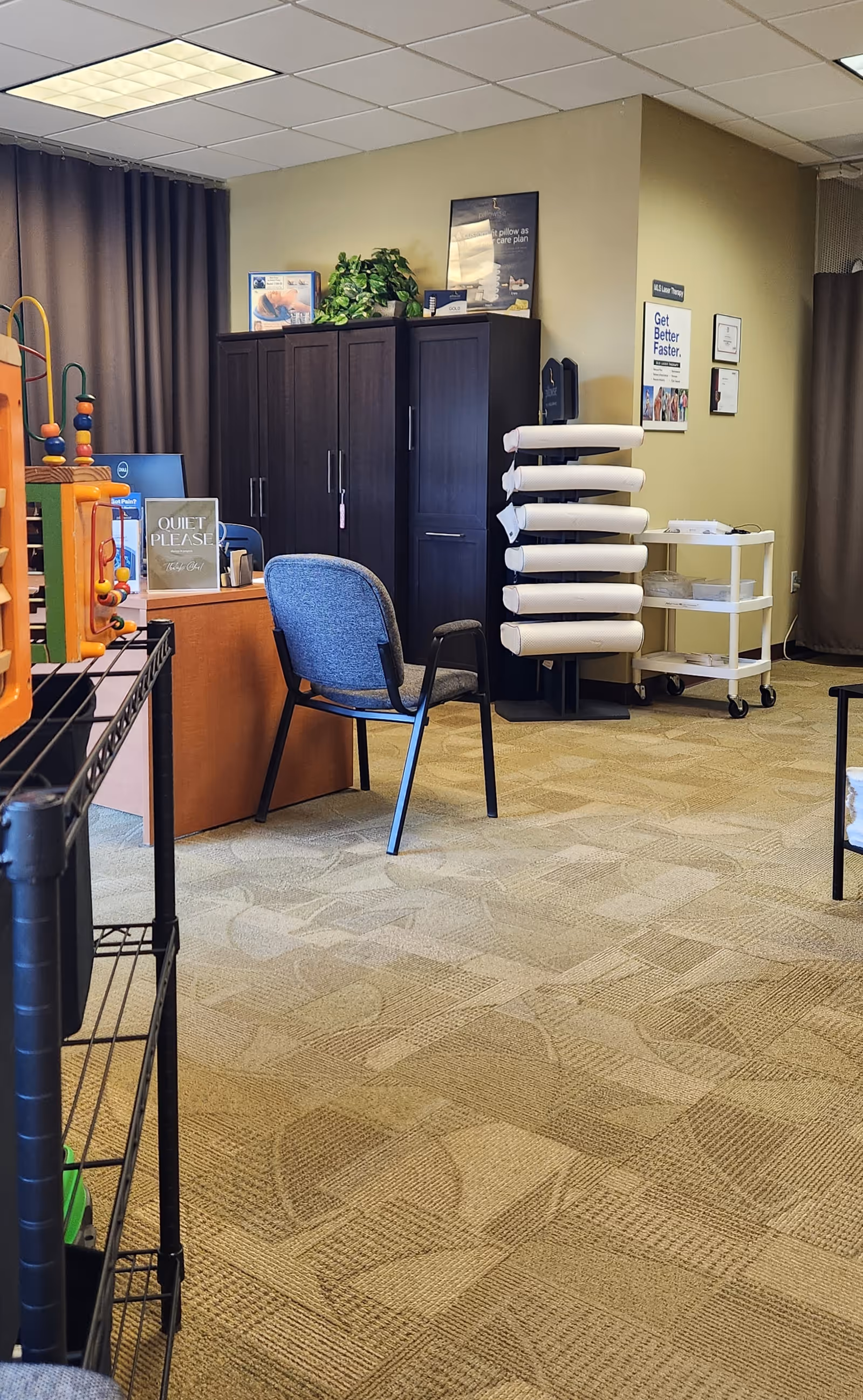 Inside a facility lounge with a blue chair, dark cabinets, and rolling mats.