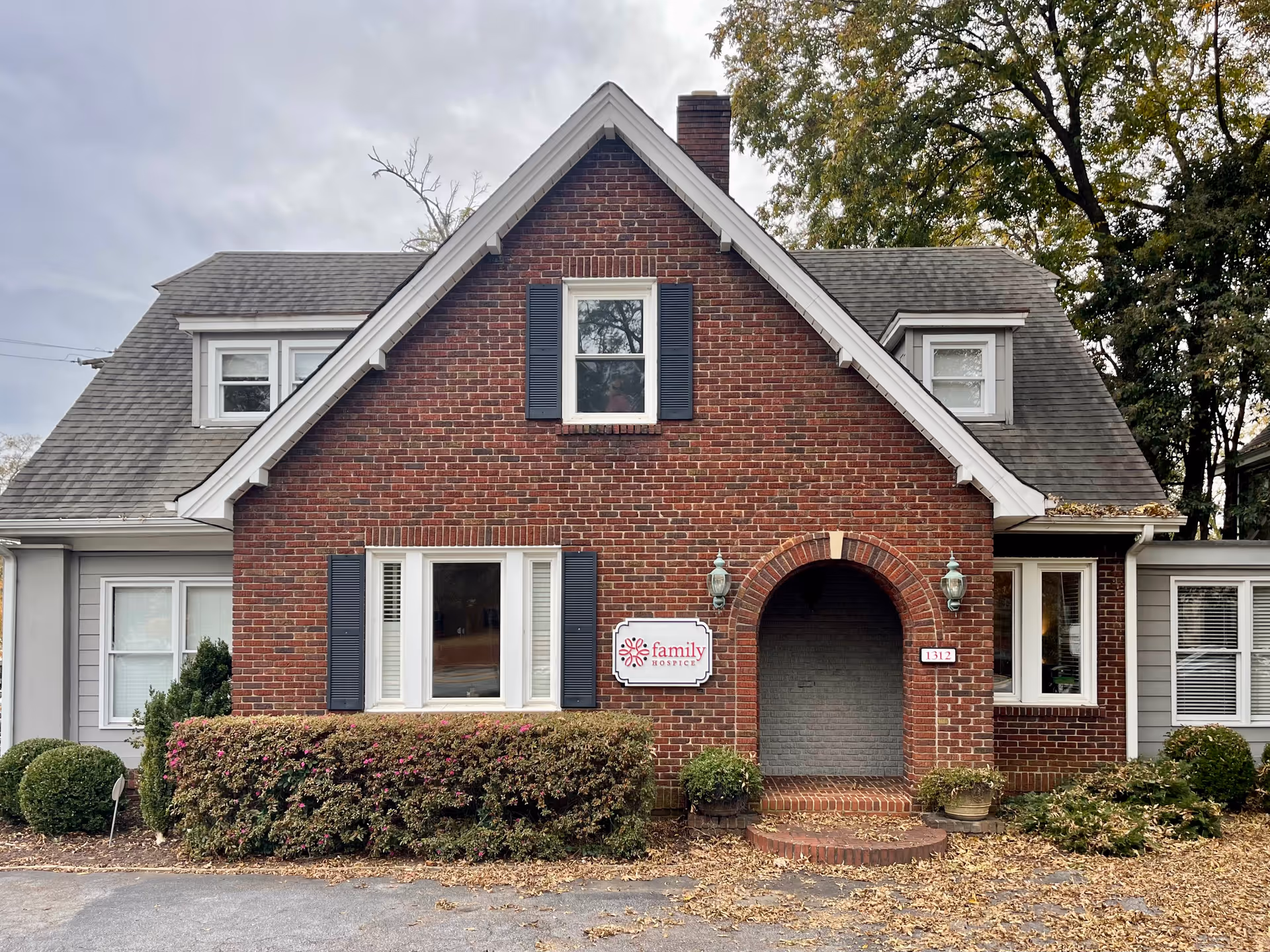 Brick building front with arched entry and Family Hospice sign.