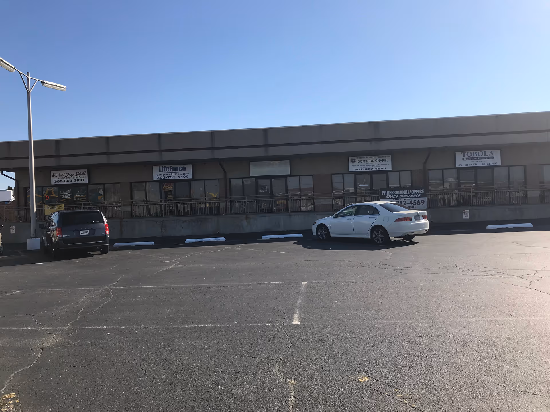 Front exterior of LifeForce Caregivers Inc building with storefront signs and a parking lot.