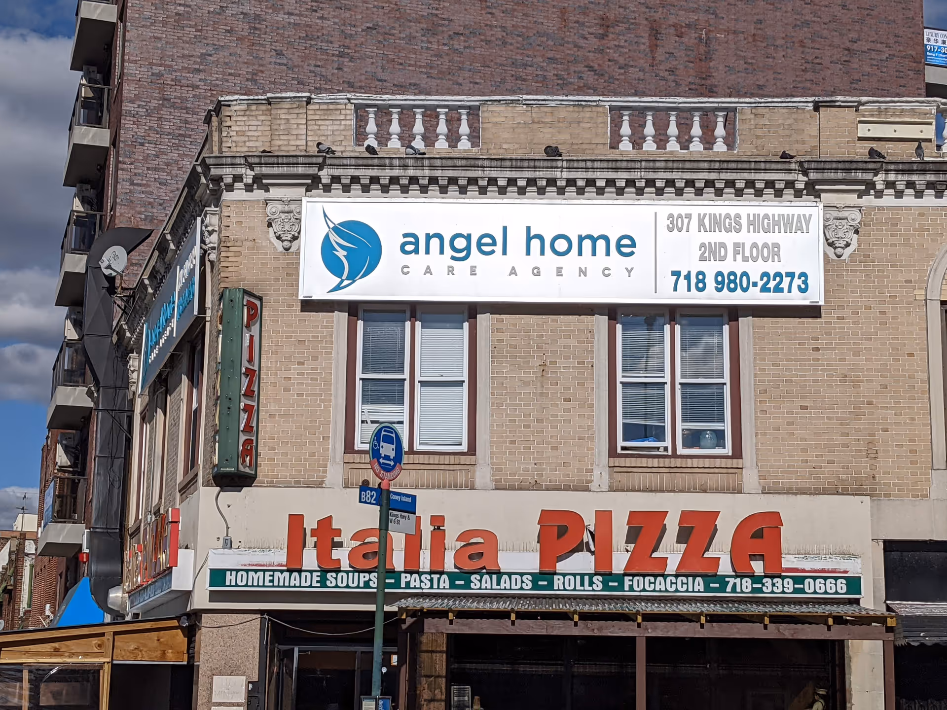 Brick building with a large Angel Home Care Agency banner above an Italian restaurant's storefront.