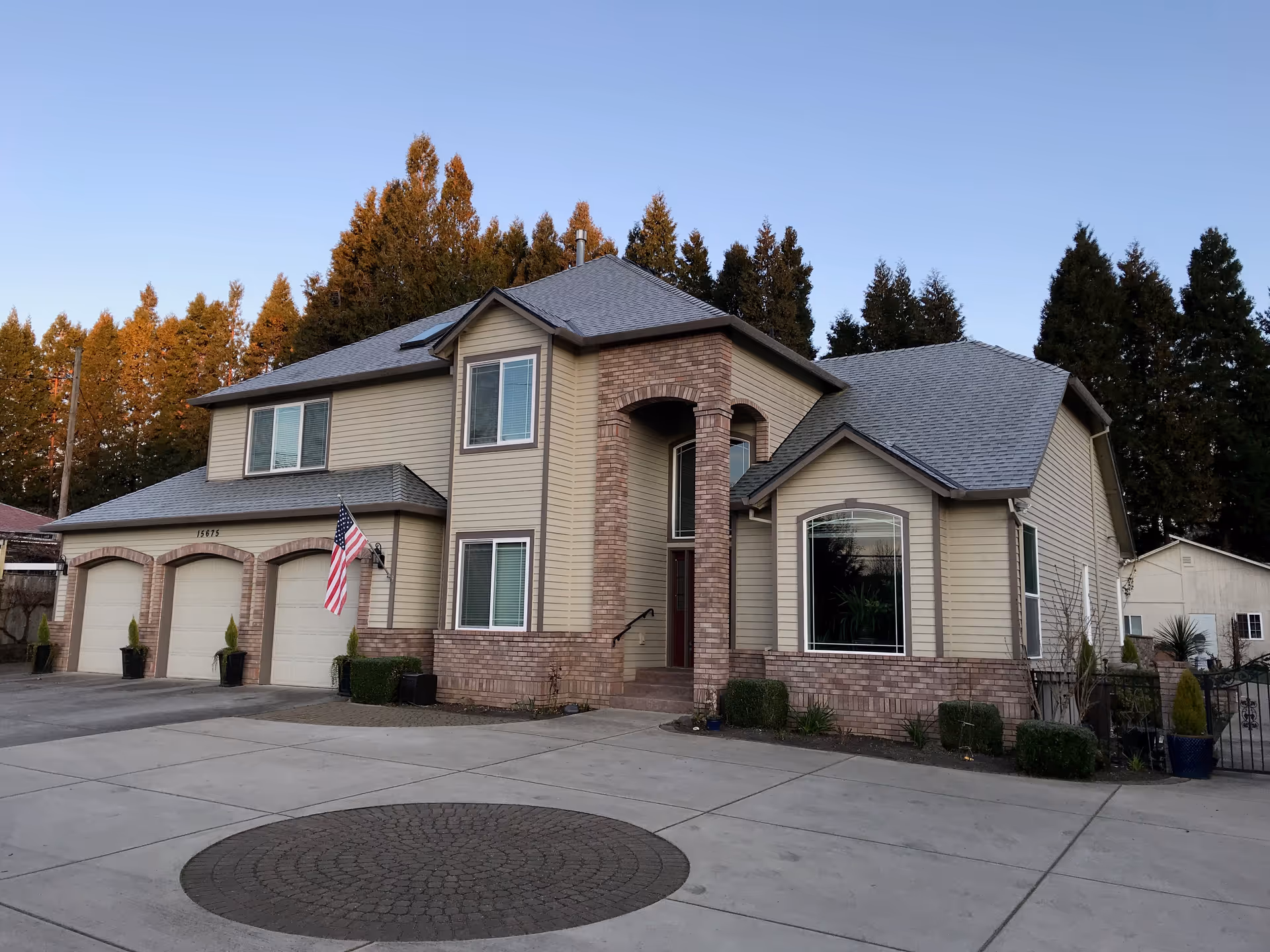 Front exterior of Vineyard Home Senior Living, a beige two-story building with brick accents and garages.