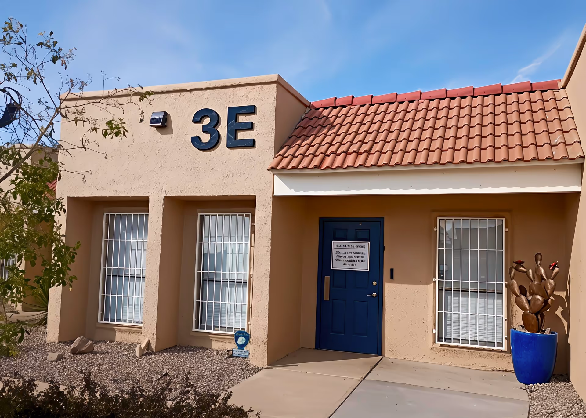 Front view of a beige senior facility with blue door and red-tiled roof.