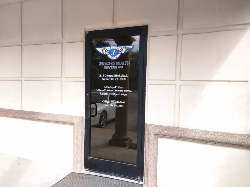 Glass door entrance with Jericho Health Services logo on a beige exterior wall.
