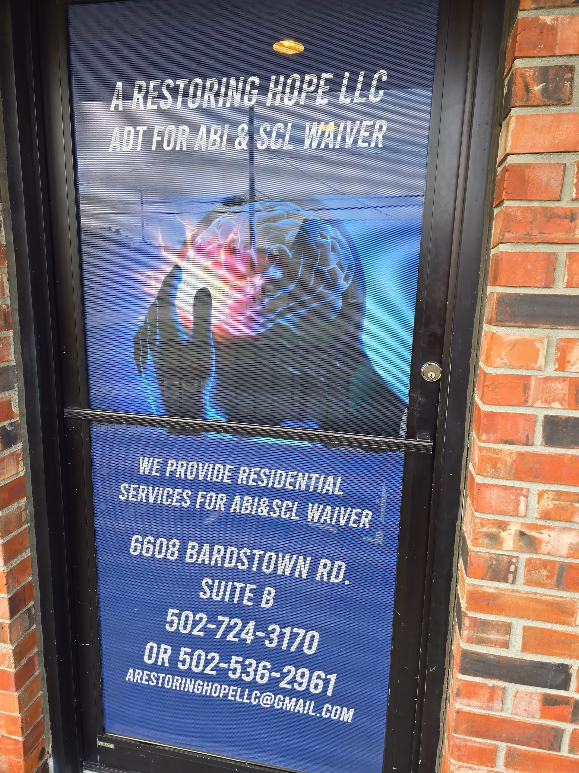Exterior door with blue sign advertising A Restoring Hope LLC and contact information.