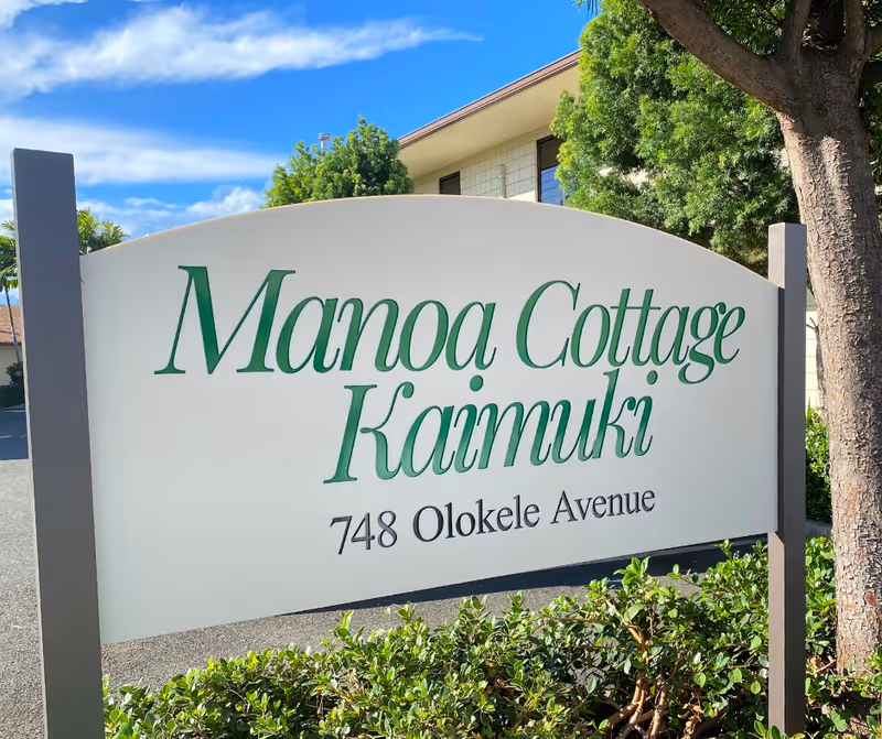 A curved exterior sign reads Manoa Cottage Kaimuki with address 748 Olokele Avenue.